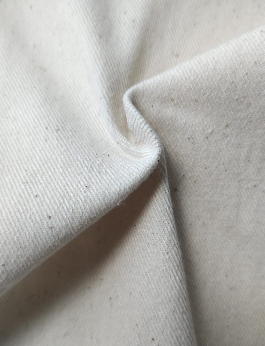Close-up of soft, wrinkled pink cotton fabric displaying fine weave texture.