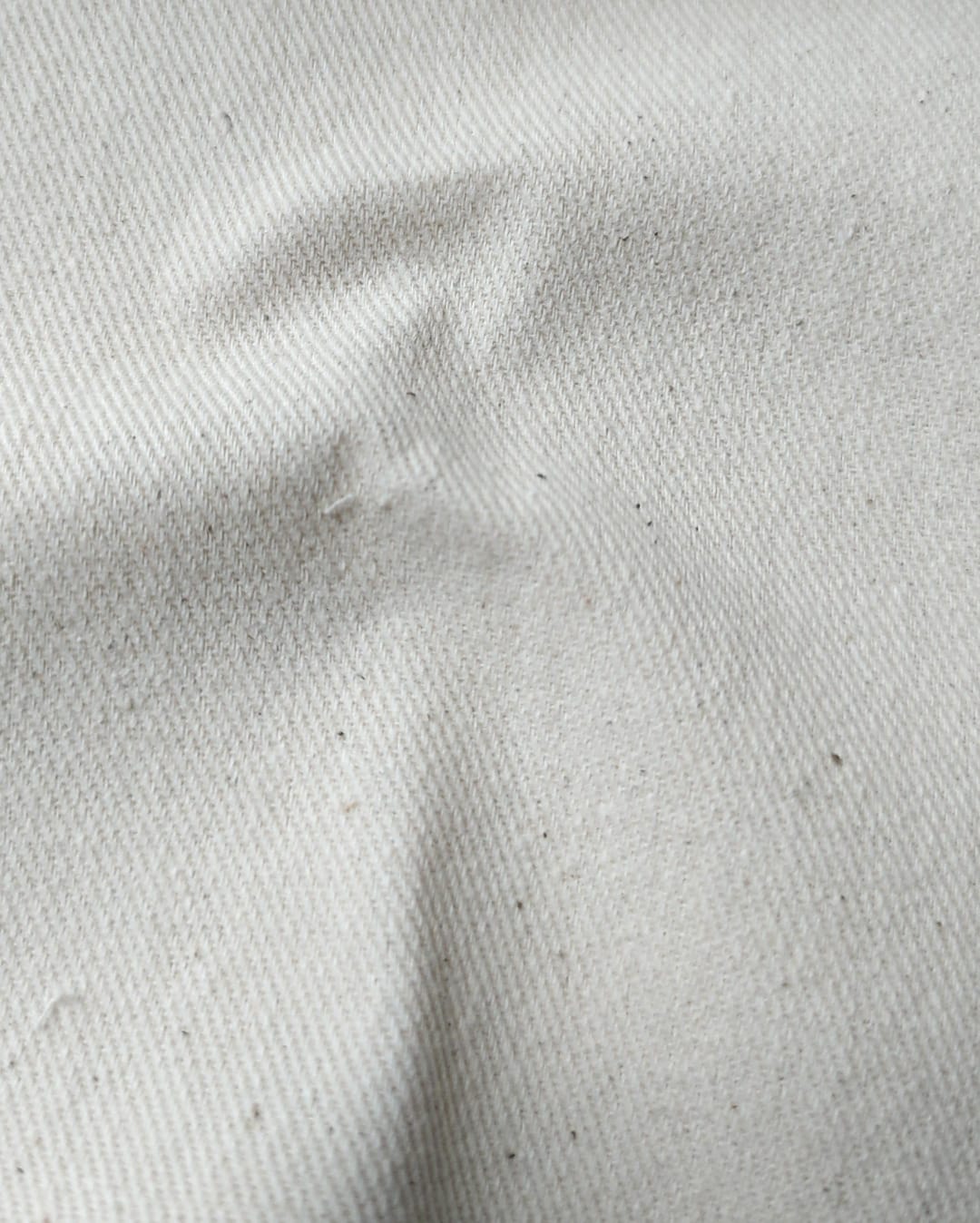 Close-up of soft, wrinkled pink cotton fabric displaying fine weave texture.