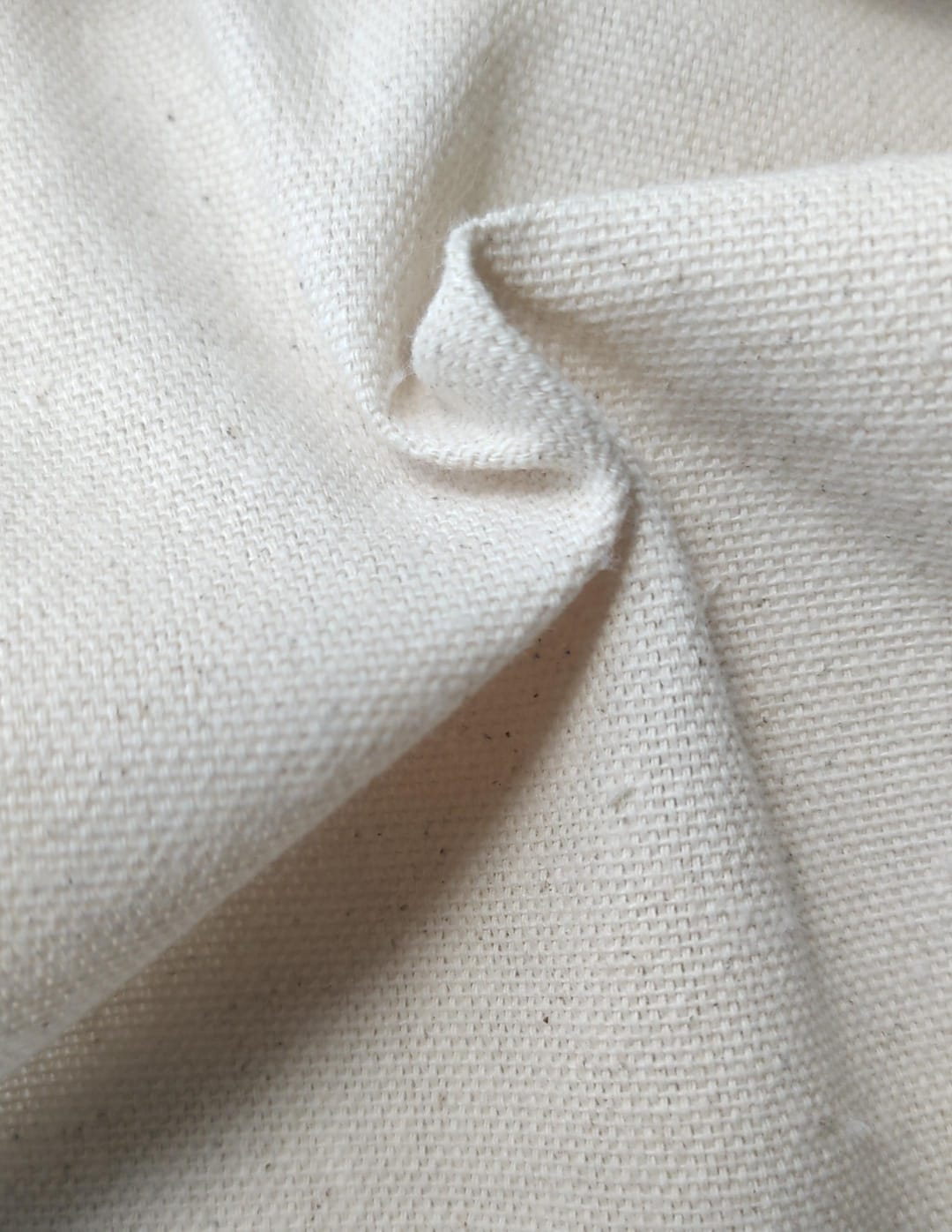 Close-up of soft, wrinkled pink cotton fabric displaying fine weave texture.