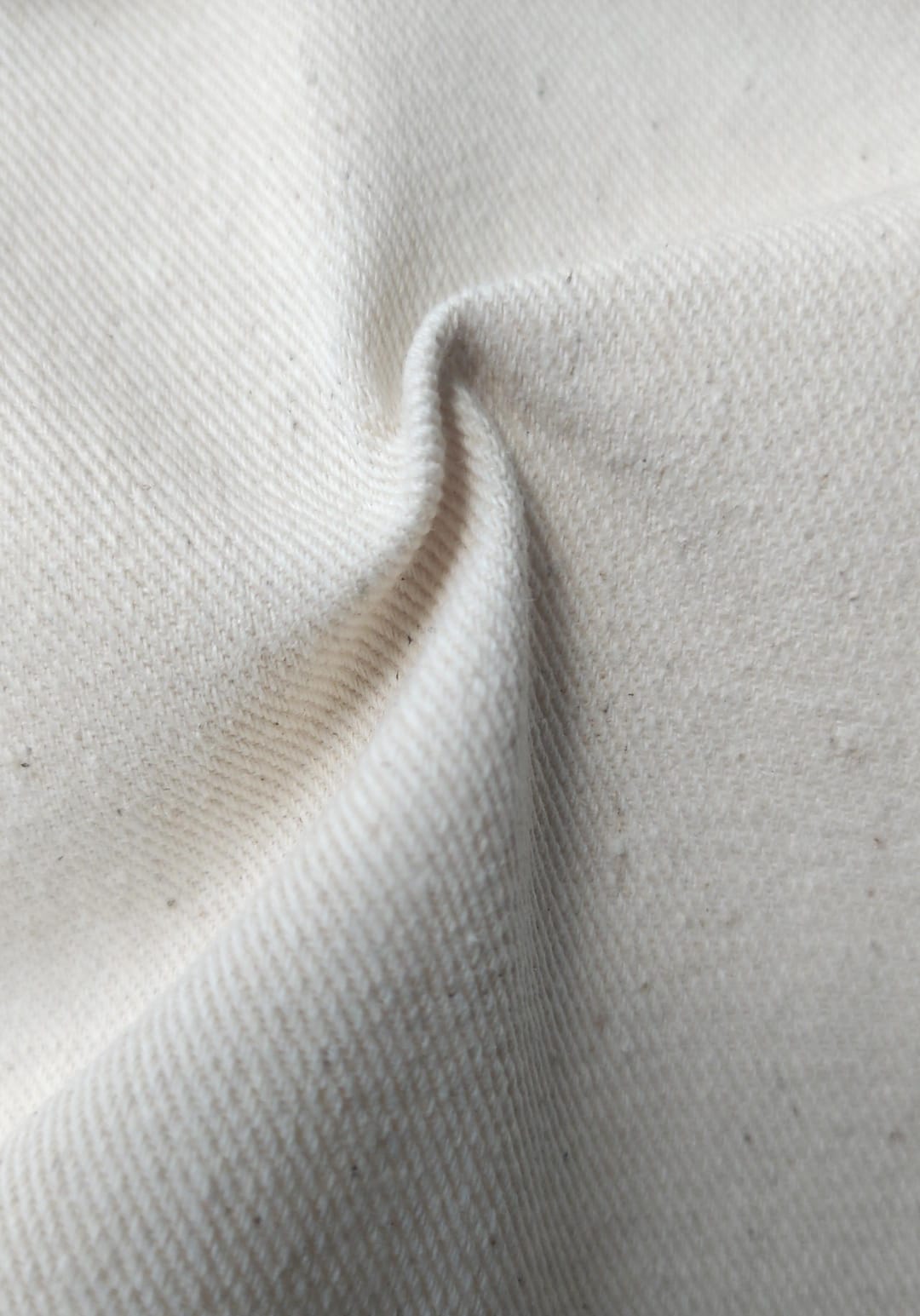 Close-up of soft, wrinkled pink cotton fabric displaying fine weave texture.