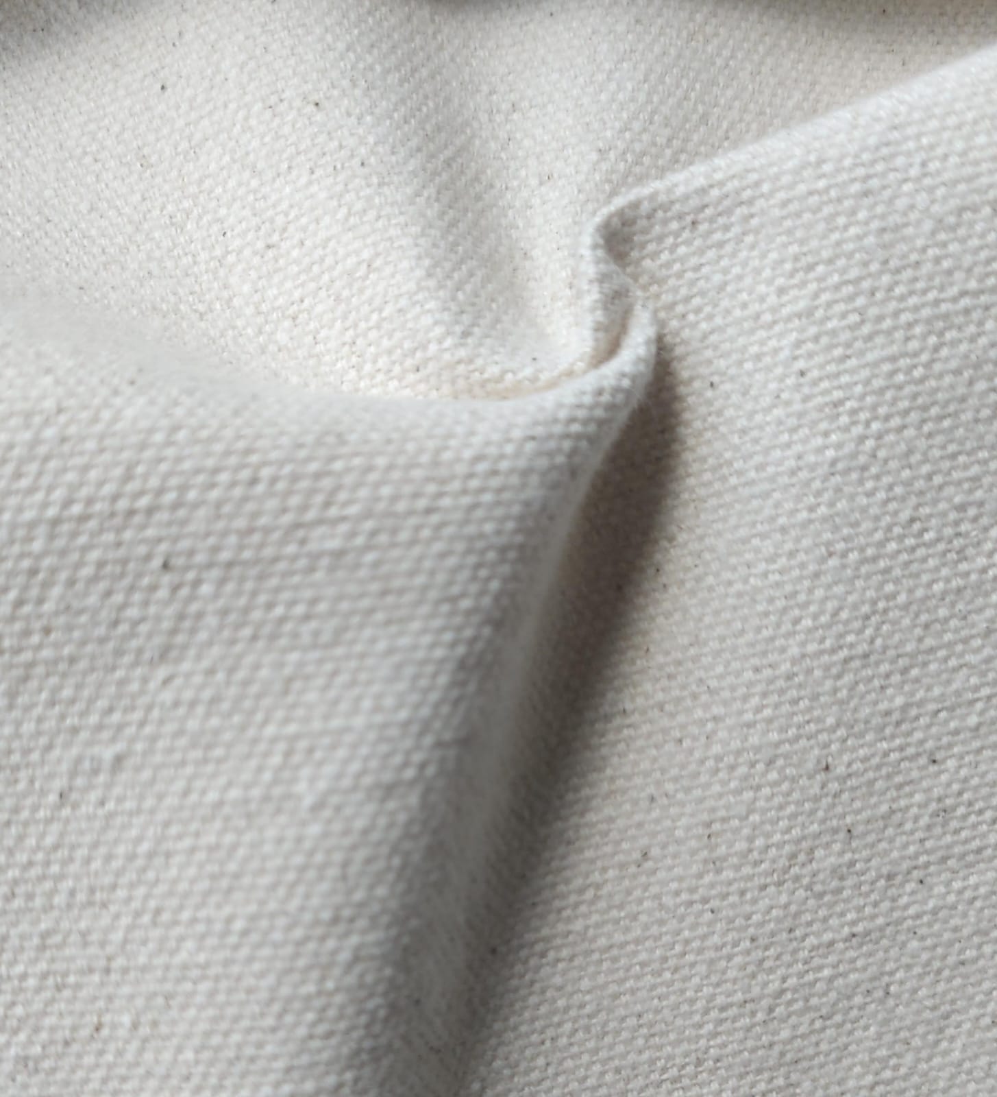 Close-up of soft, wrinkled pink cotton fabric displaying fine weave texture.