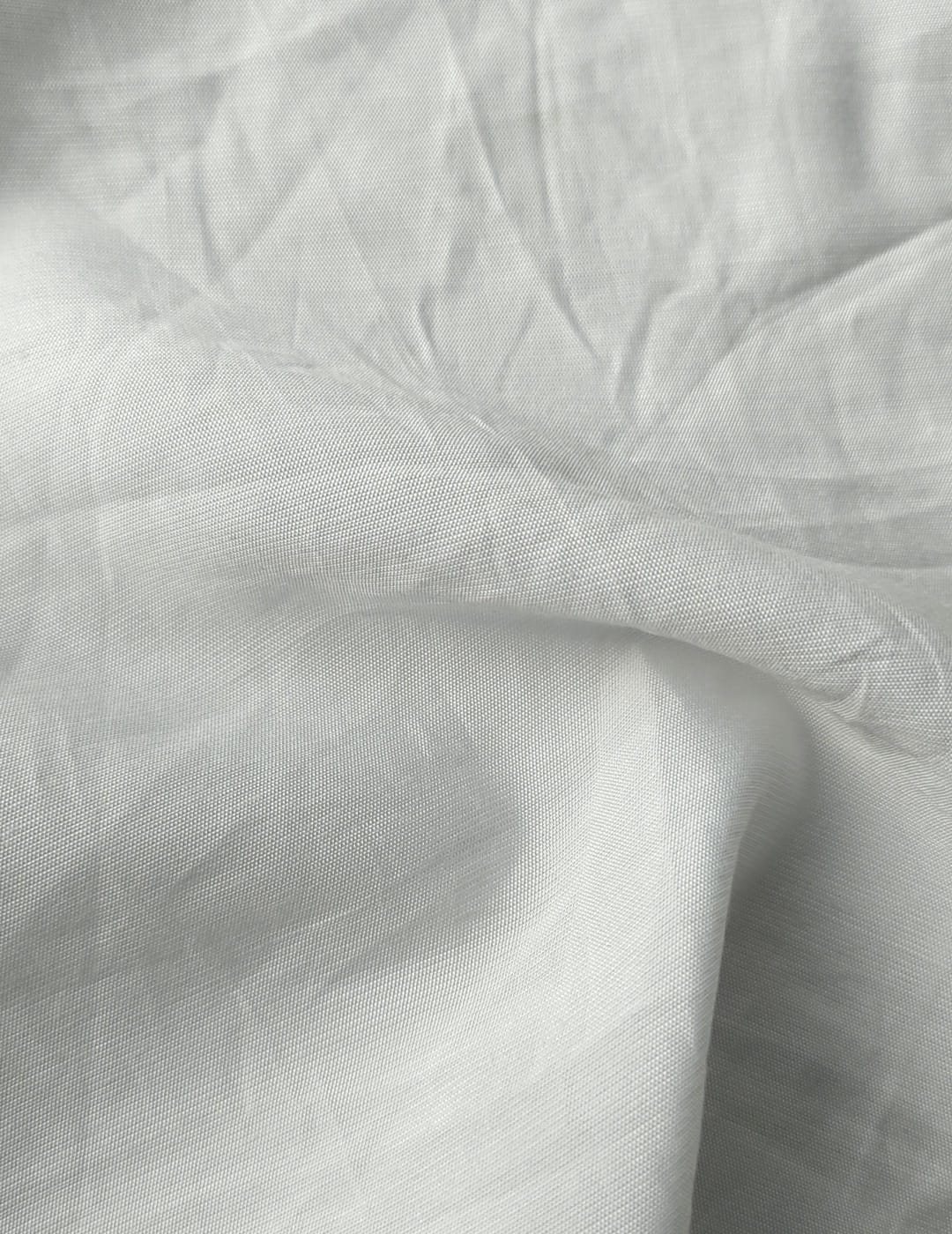 Close-up of soft, wrinkled pink cotton fabric displaying fine weave texture.