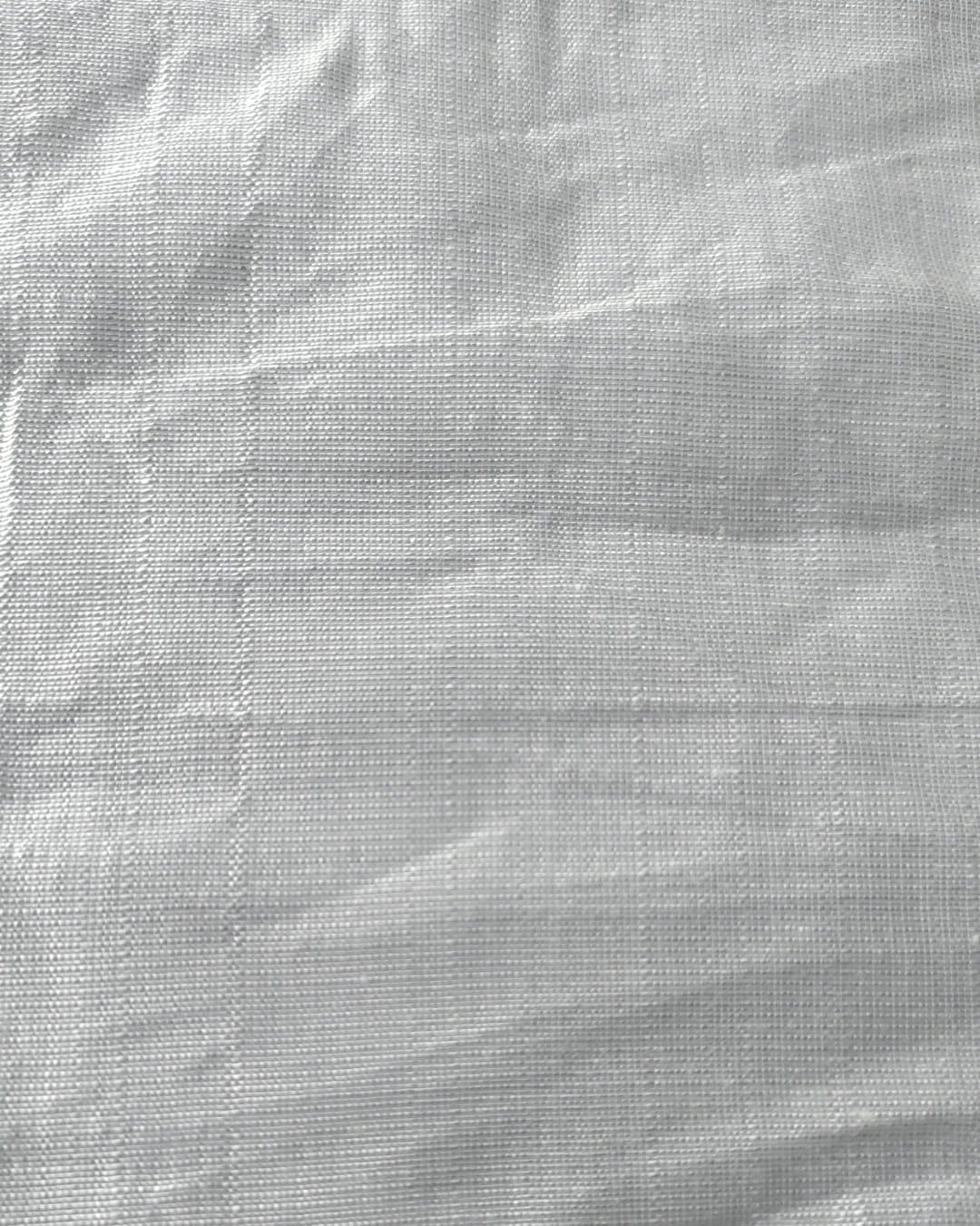 Close-up of soft, wrinkled pink cotton fabric displaying fine weave texture.