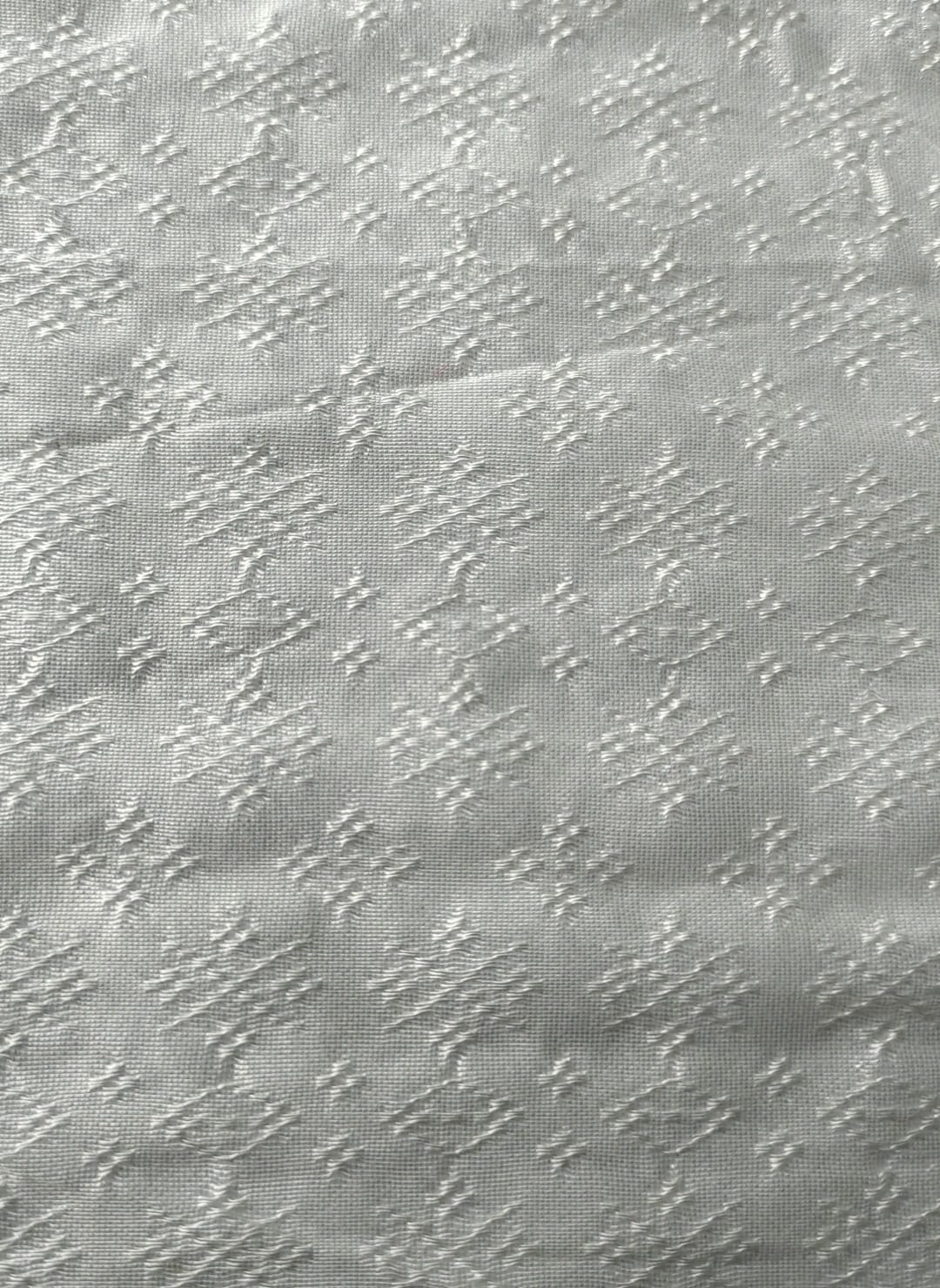 Close-up of soft, wrinkled pink cotton fabric displaying fine weave texture.