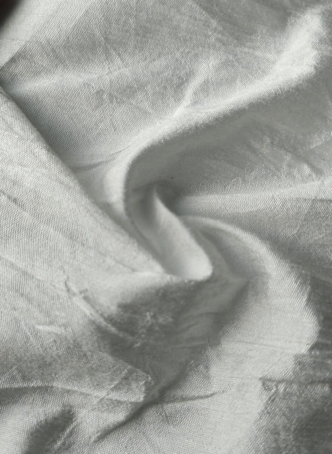 Close-up of soft, wrinkled pink cotton fabric displaying fine weave texture.