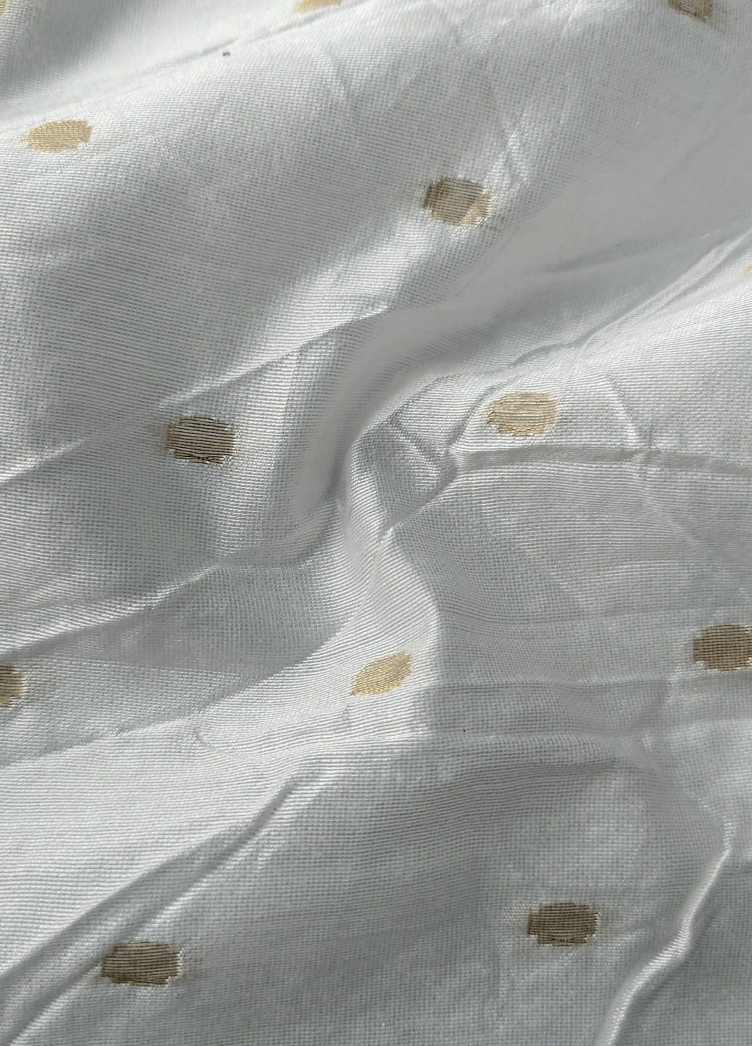 Close-up of soft, wrinkled pink cotton fabric displaying fine weave texture.