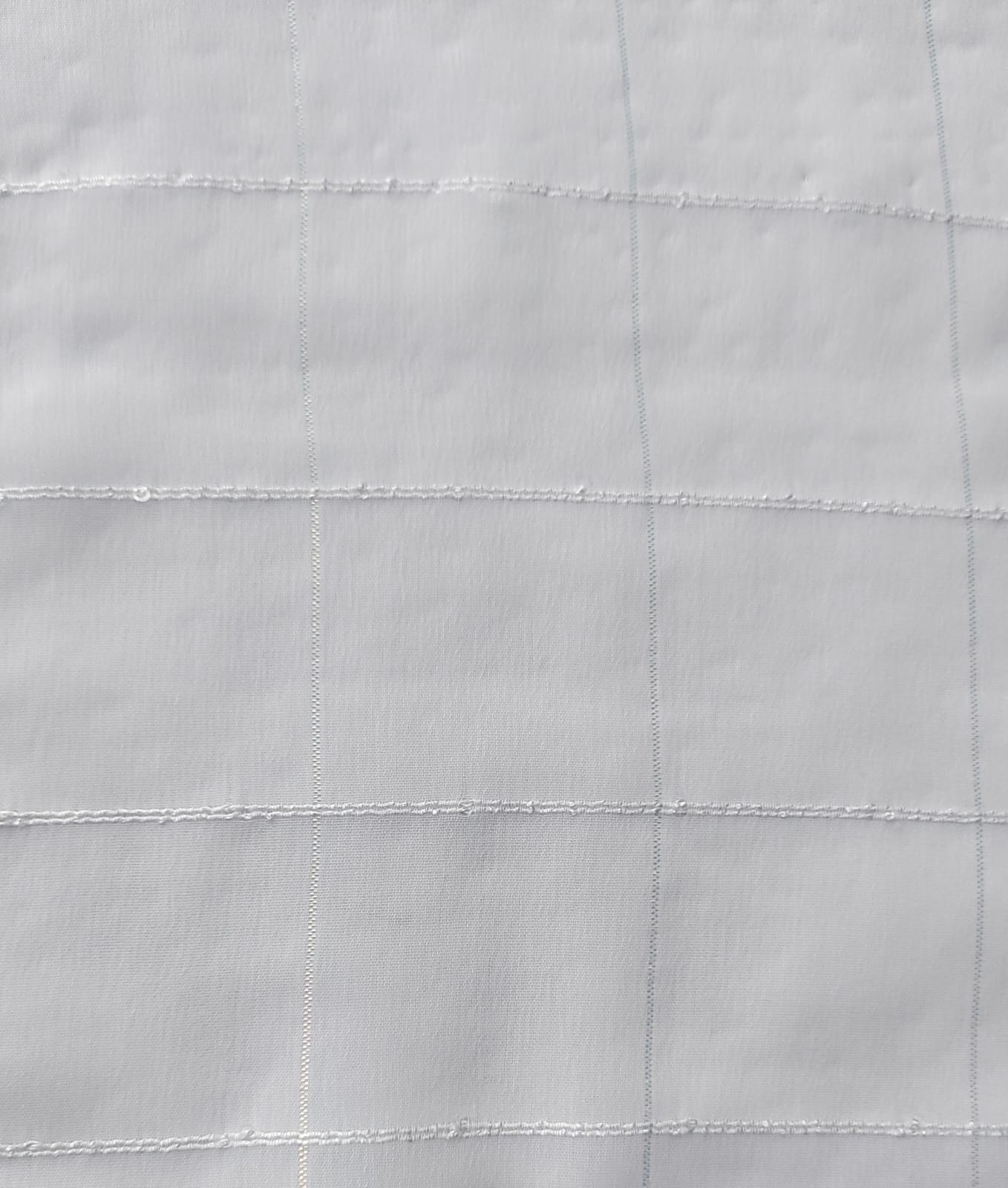 Close-up of soft, wrinkled pink cotton fabric displaying fine weave texture.