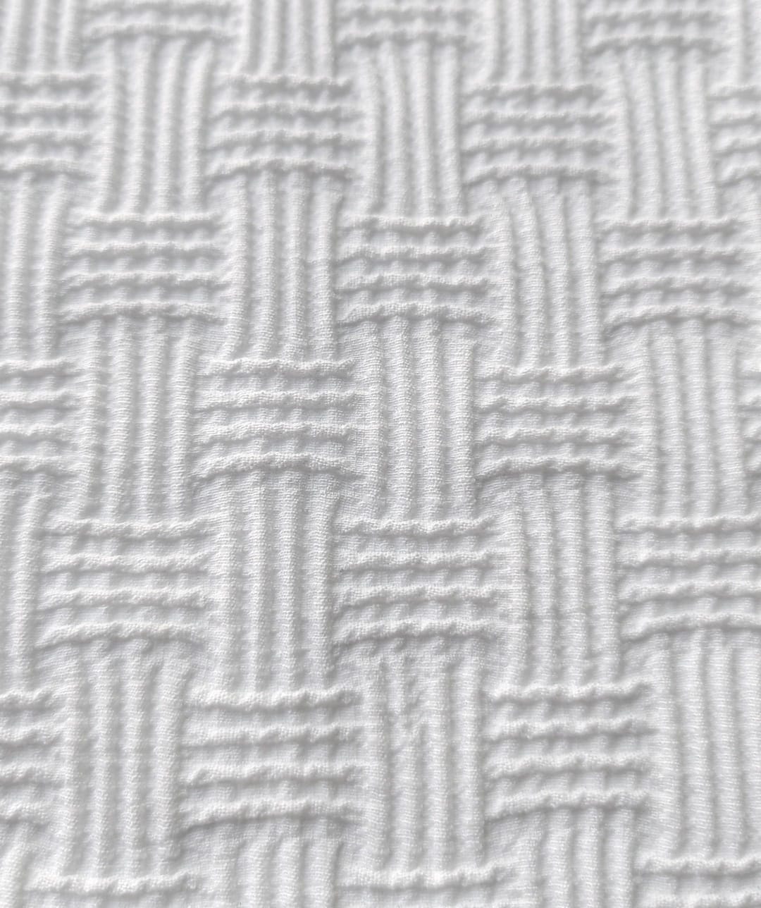 Close-up of soft, wrinkled pink cotton fabric displaying fine weave texture.