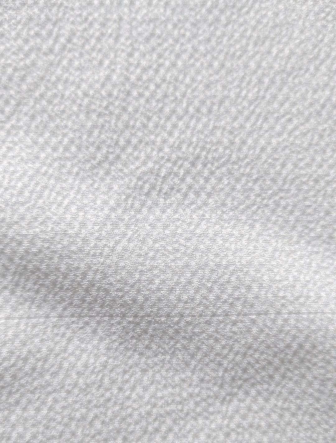 Close-up of soft, wrinkled pink cotton fabric displaying fine weave texture.