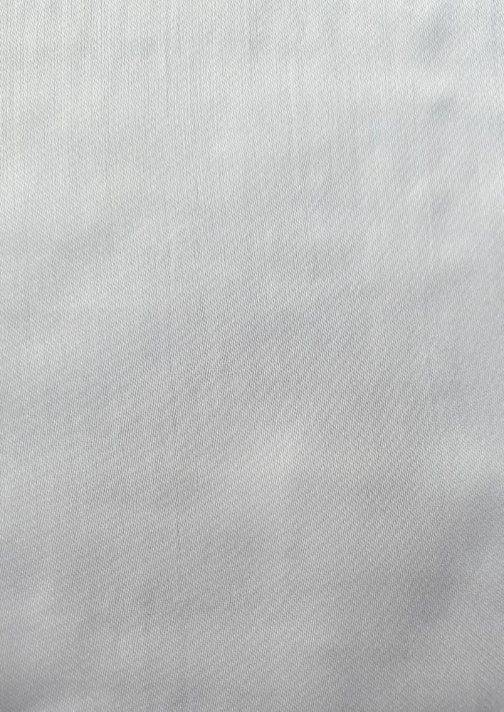 Close-up of soft, wrinkled pink cotton fabric displaying fine weave texture.