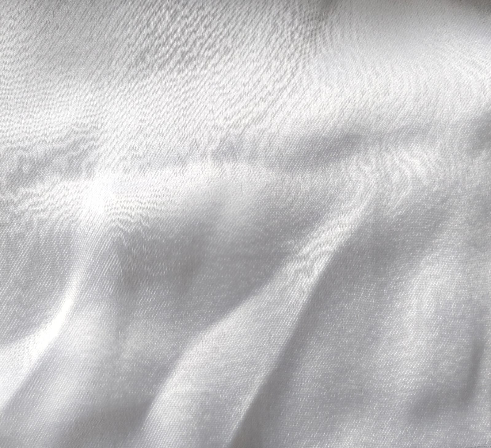 Close-up of soft, wrinkled pink cotton fabric displaying fine weave texture.