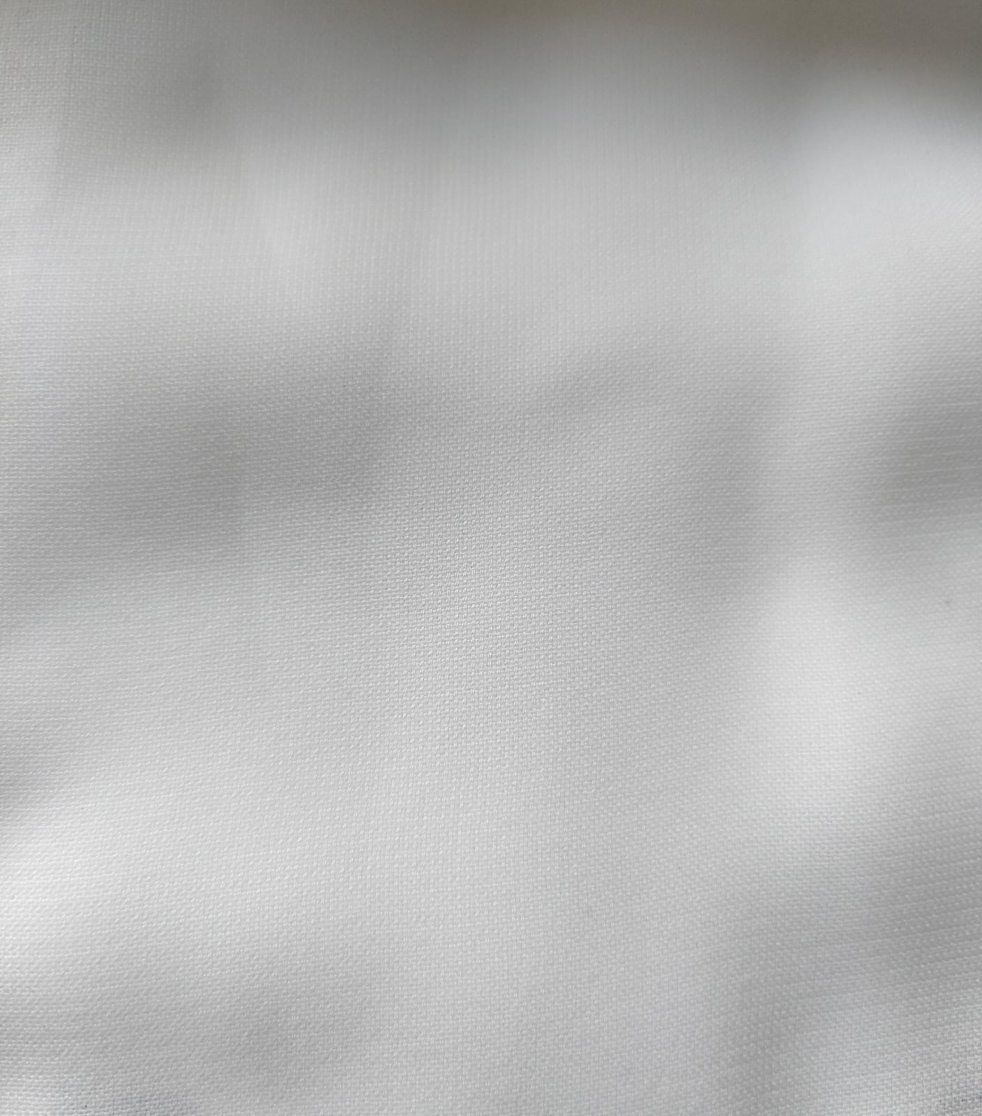 Close-up of soft, wrinkled pink cotton fabric displaying fine weave texture.