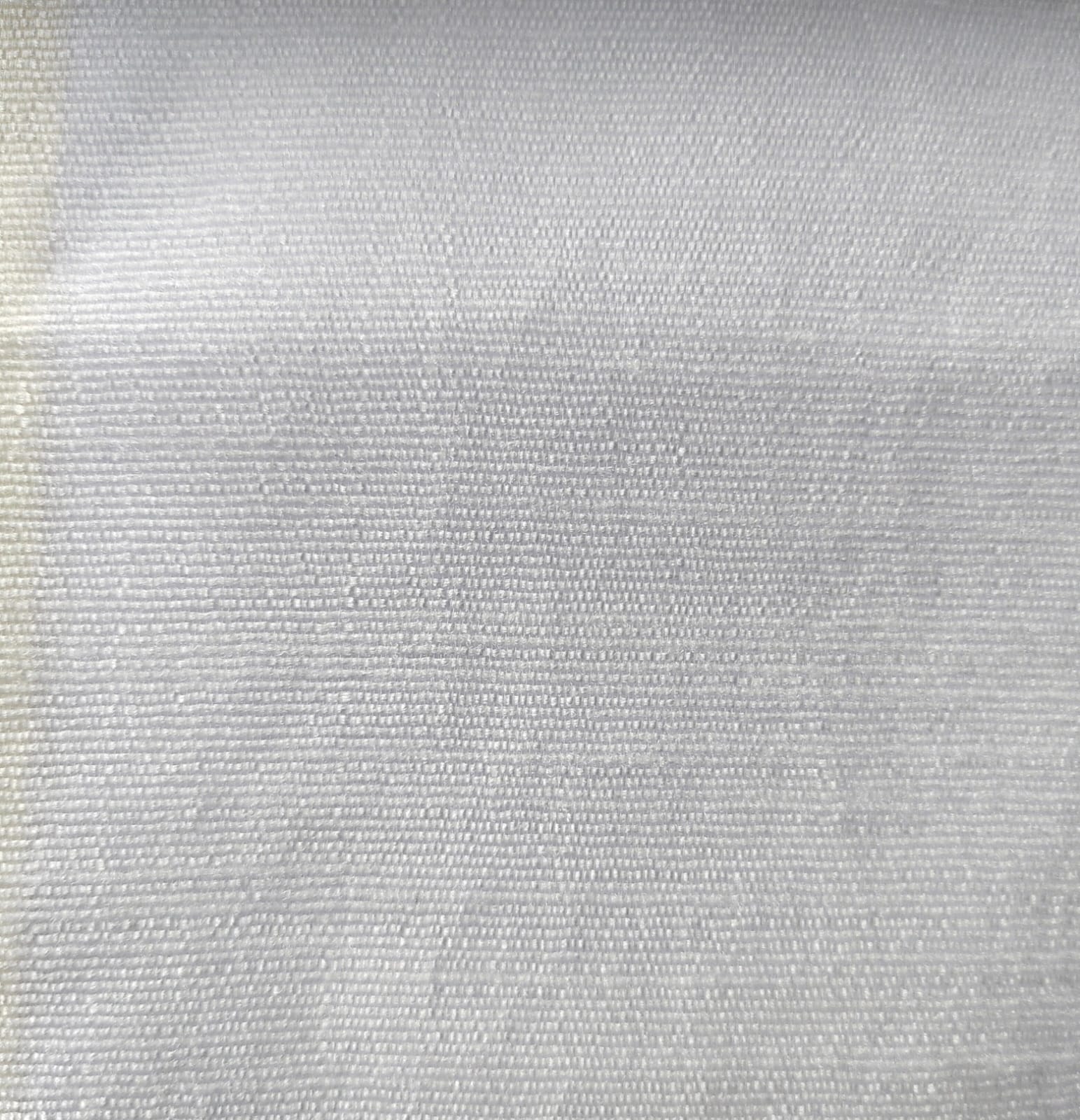Close-up of soft, wrinkled pink cotton fabric displaying fine weave texture.