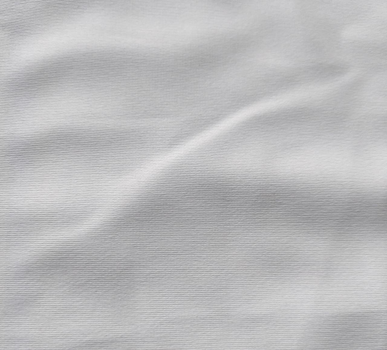 Close-up of soft, wrinkled pink cotton fabric displaying fine weave texture.