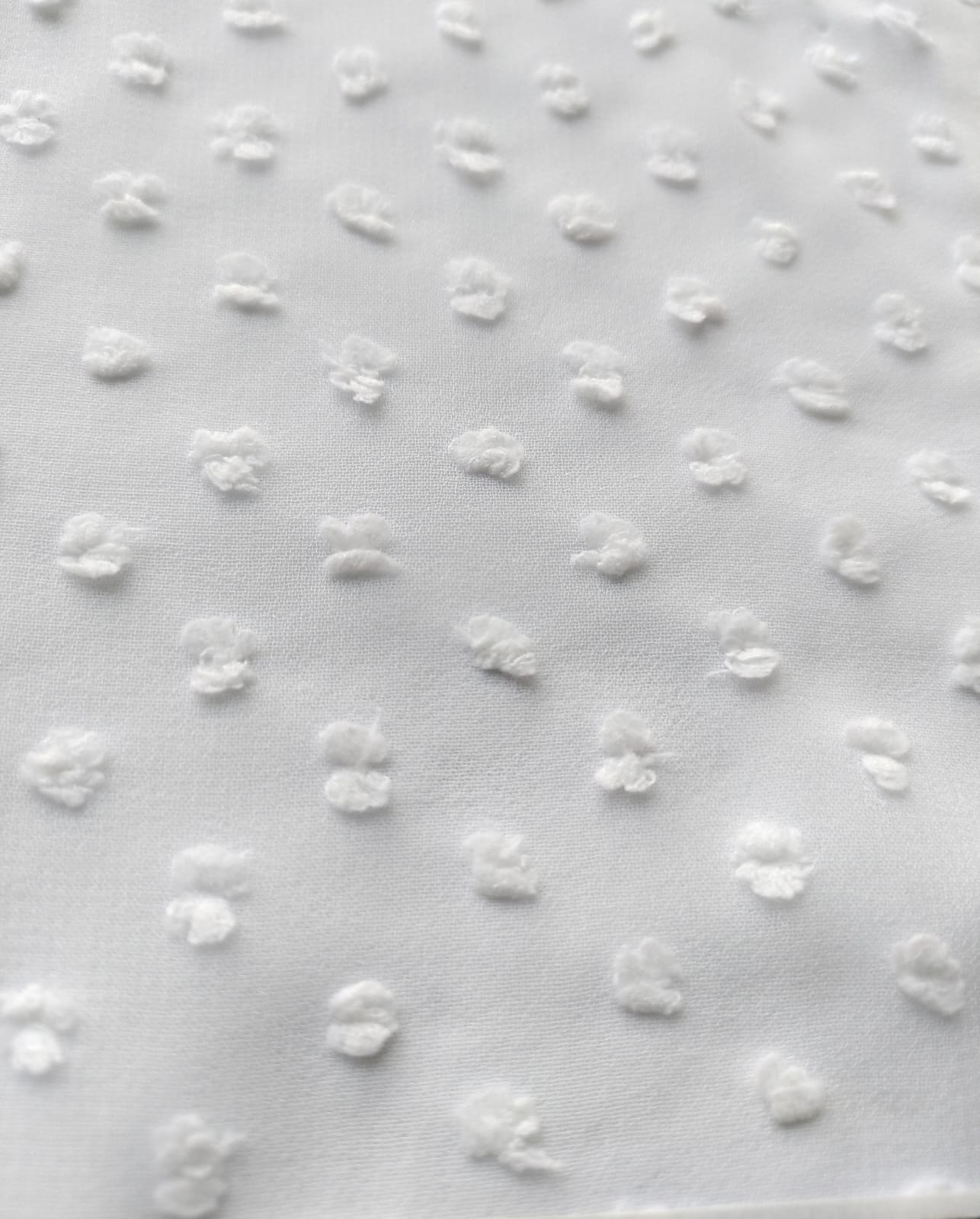 Close-up of soft, wrinkled pink cotton fabric displaying fine weave texture.