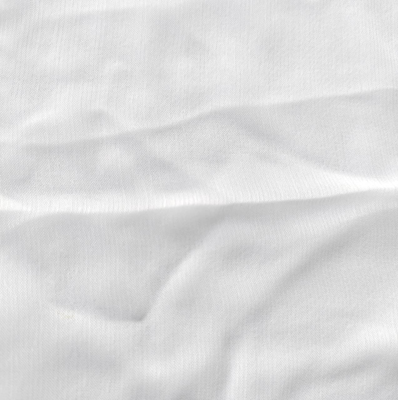 Close-up of soft, wrinkled pink cotton fabric displaying fine weave texture.
