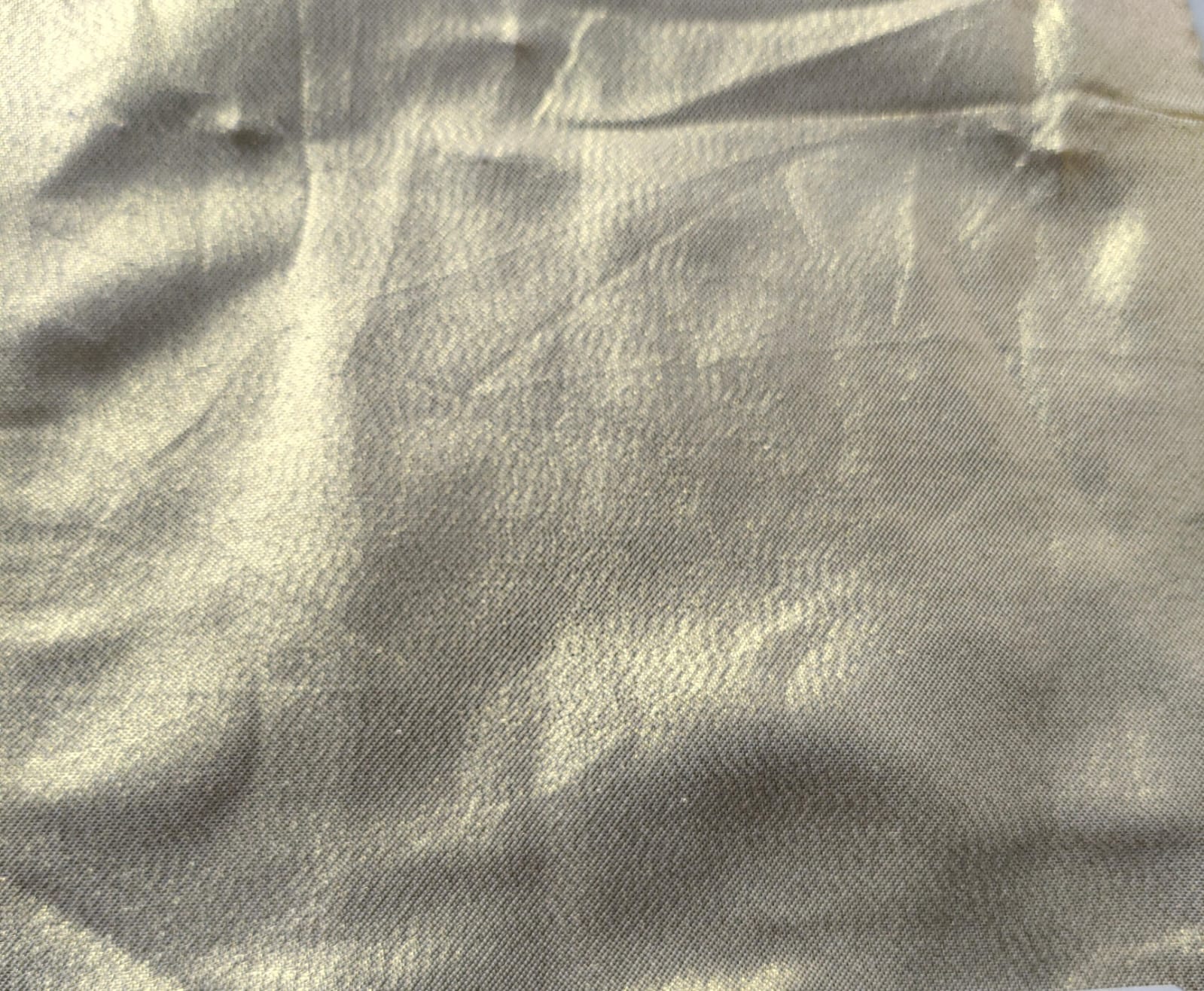 Close-up of soft, wrinkled pink cotton fabric displaying fine weave texture.