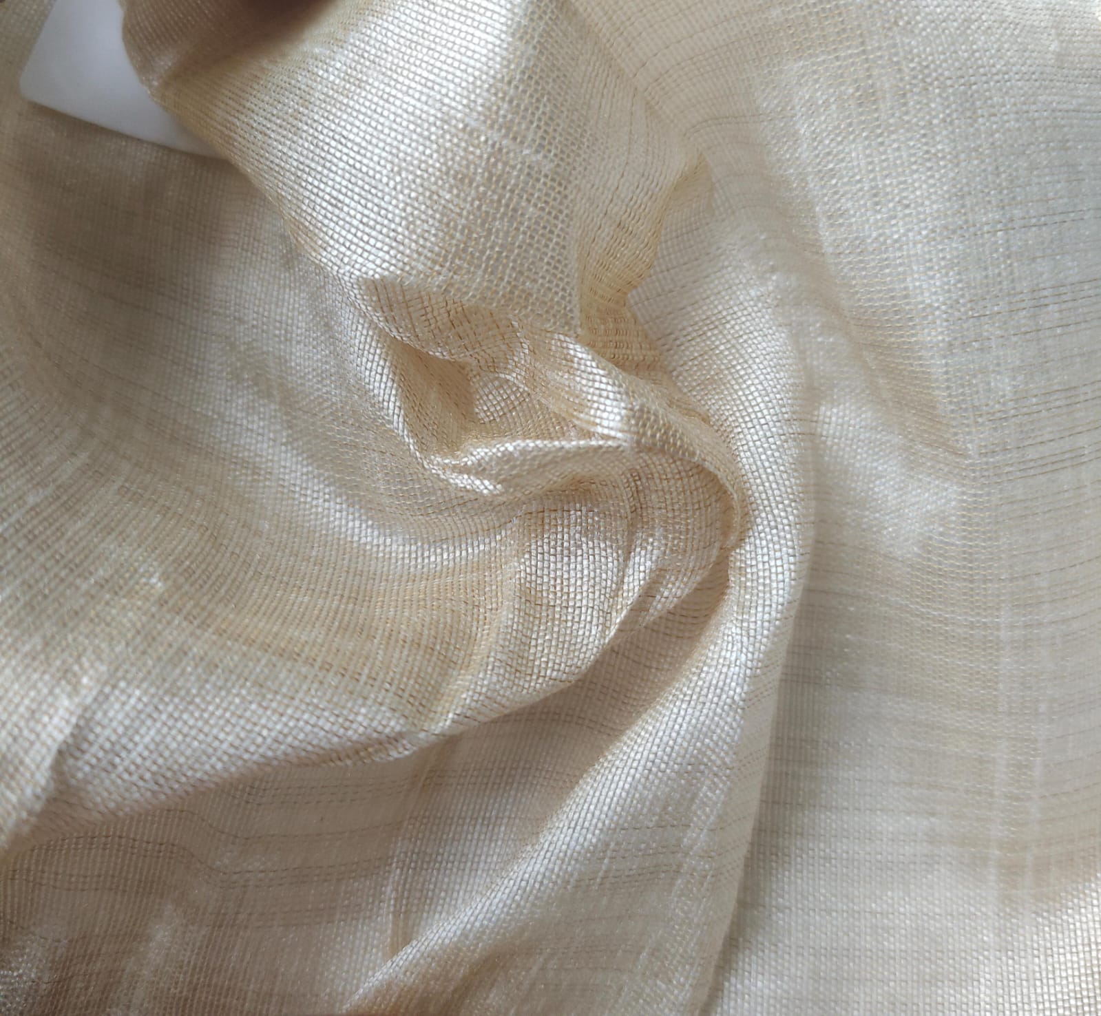 Close-up of soft, wrinkled pink cotton fabric displaying fine weave texture.