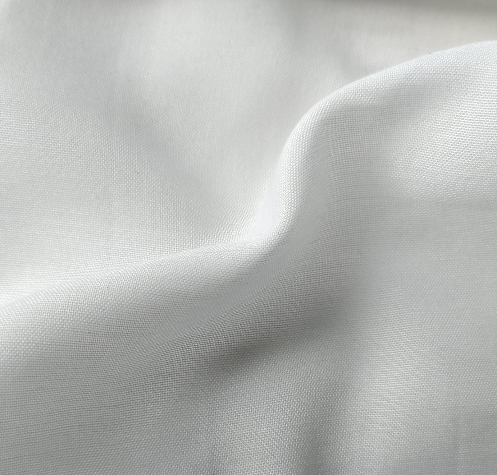 Close-up of soft, wrinkled pink cotton fabric displaying fine weave texture.