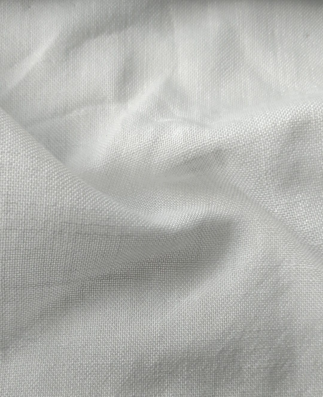 Close-up of soft, wrinkled pink cotton fabric displaying fine weave texture.