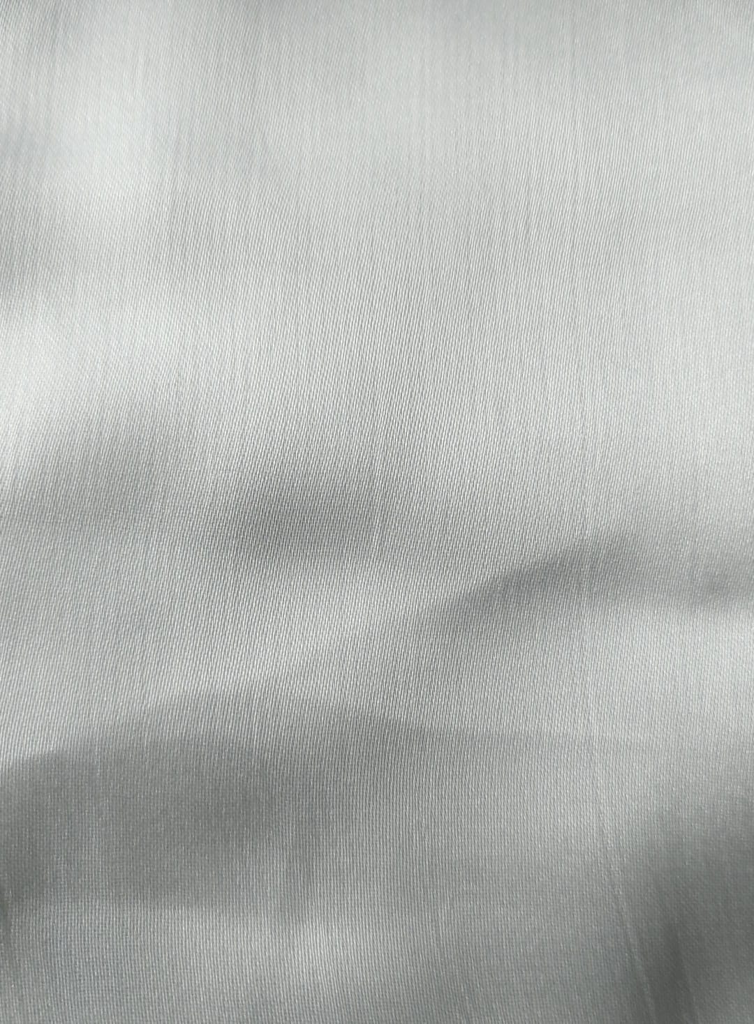 Close-up of soft, wrinkled pink cotton fabric displaying fine weave texture.