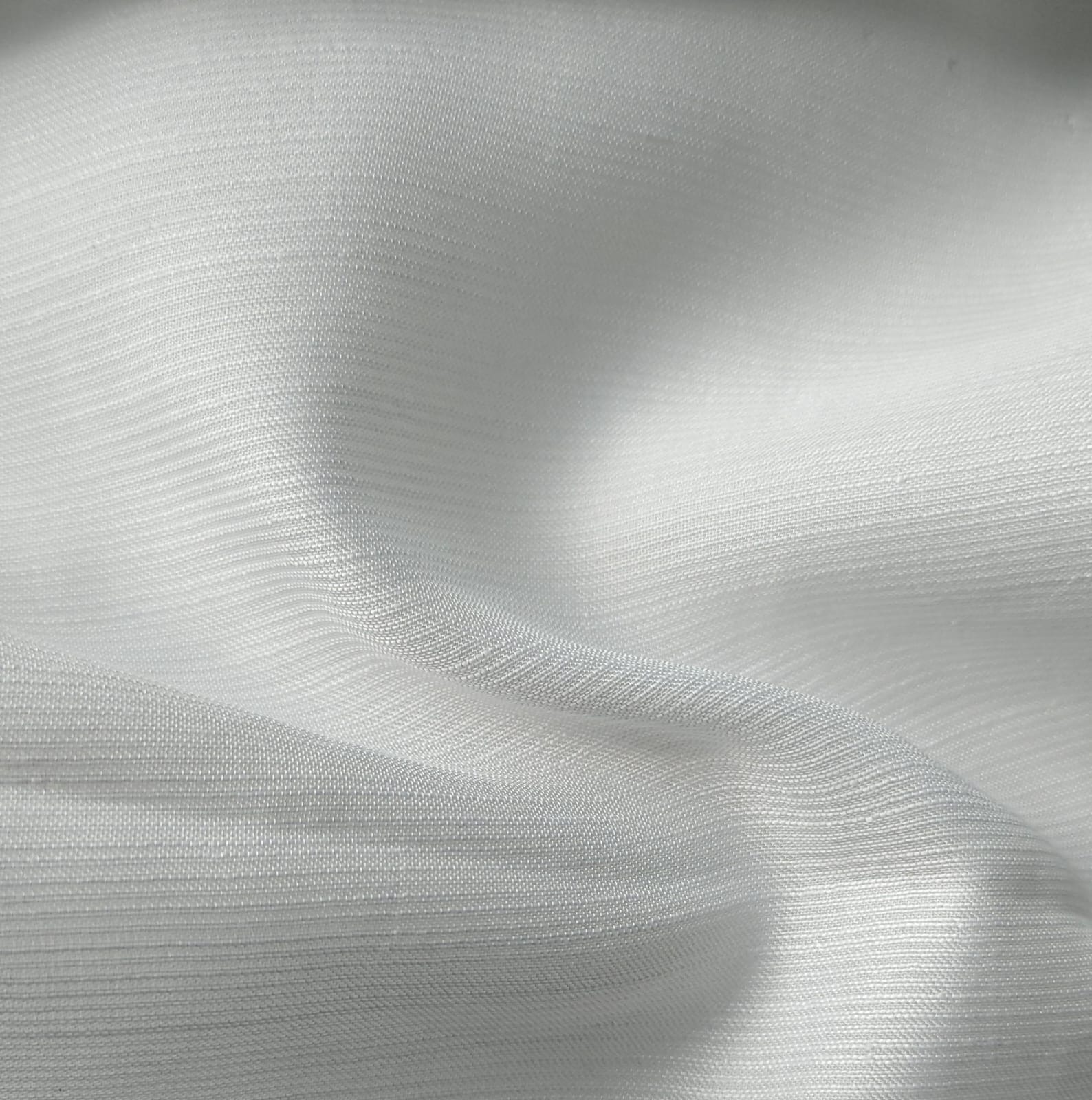 Close-up of soft, wrinkled pink cotton fabric displaying fine weave texture.