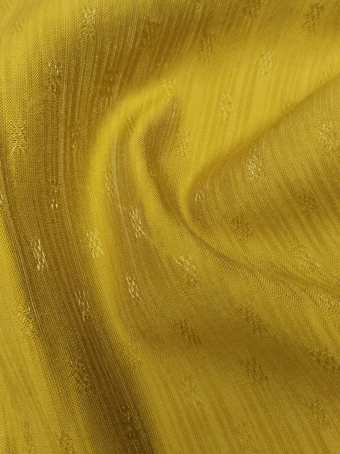Close-up of soft, wrinkled pink cotton fabric displaying fine weave texture.