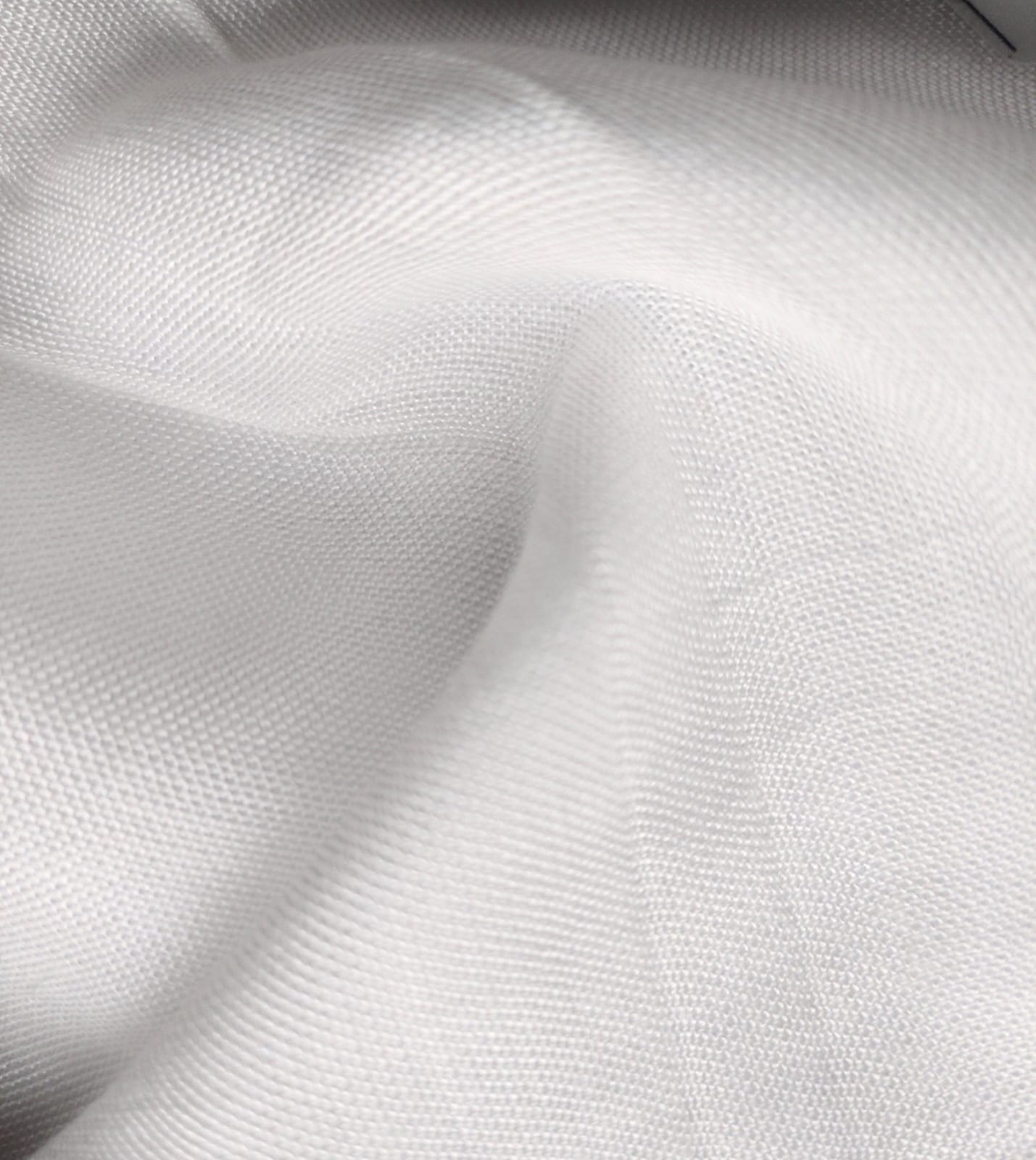 Close-up of soft, wrinkled pink cotton fabric displaying fine weave texture.