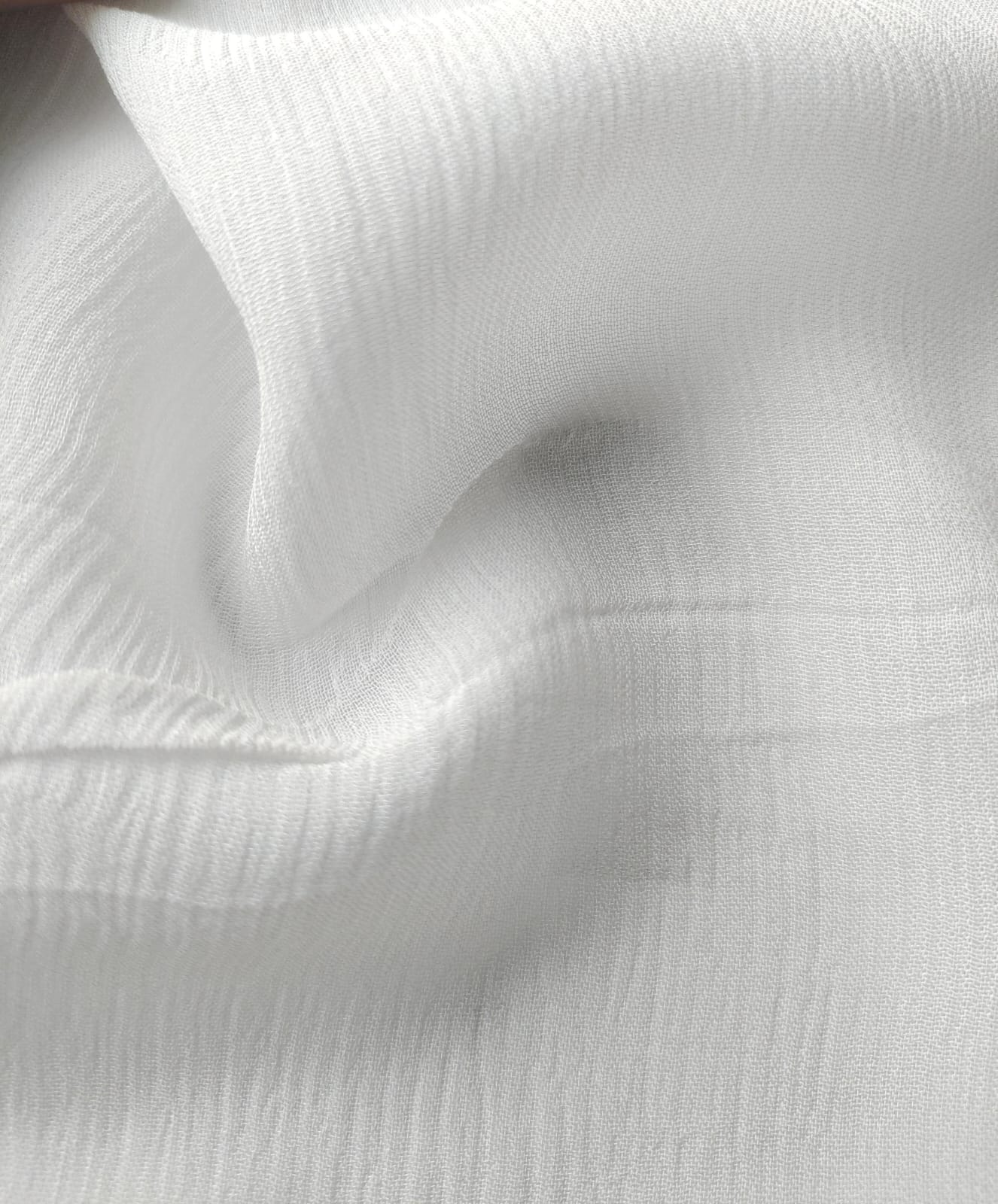 Close-up of soft, wrinkled pink cotton fabric displaying fine weave texture.
