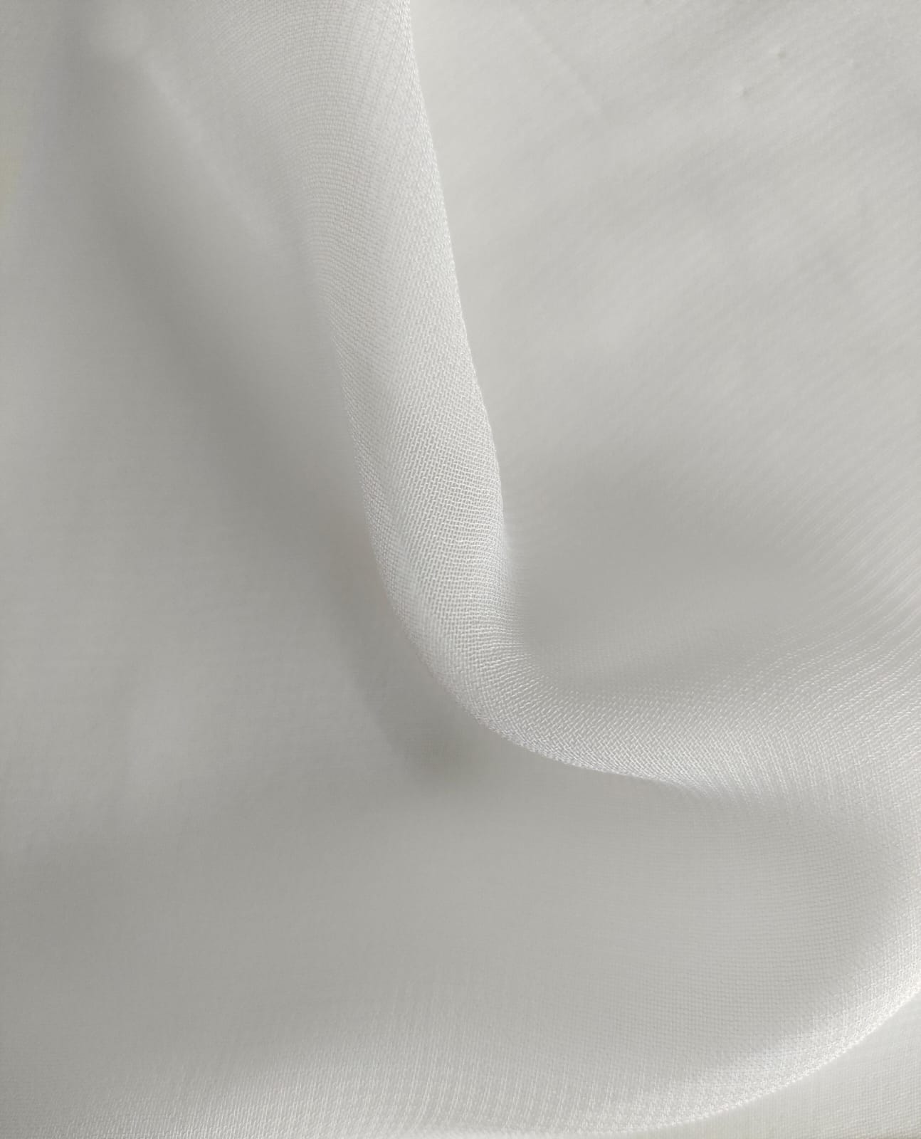 Close-up of soft, wrinkled pink cotton fabric displaying fine weave texture.