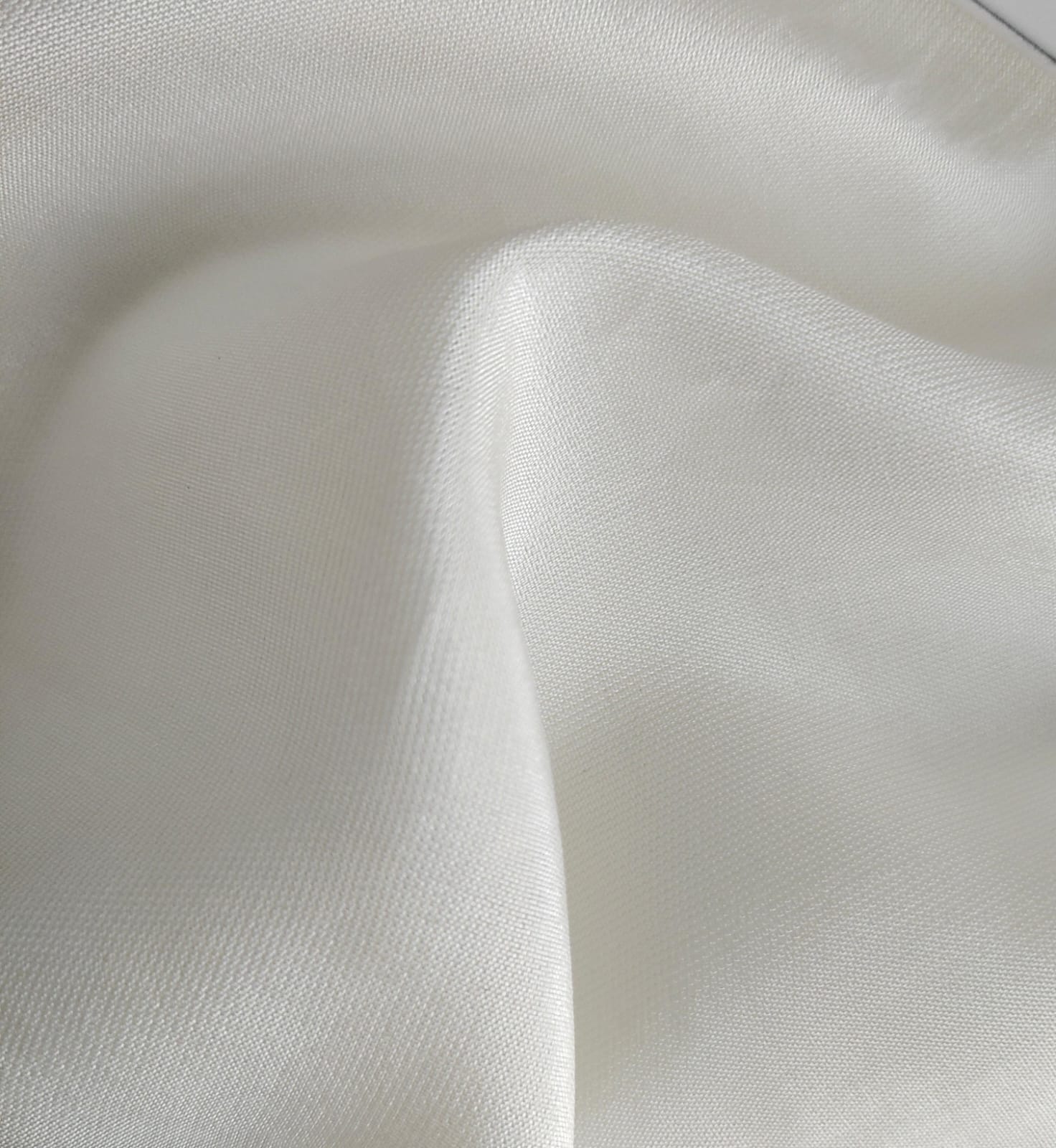 Close-up of soft, wrinkled pink cotton fabric displaying fine weave texture.