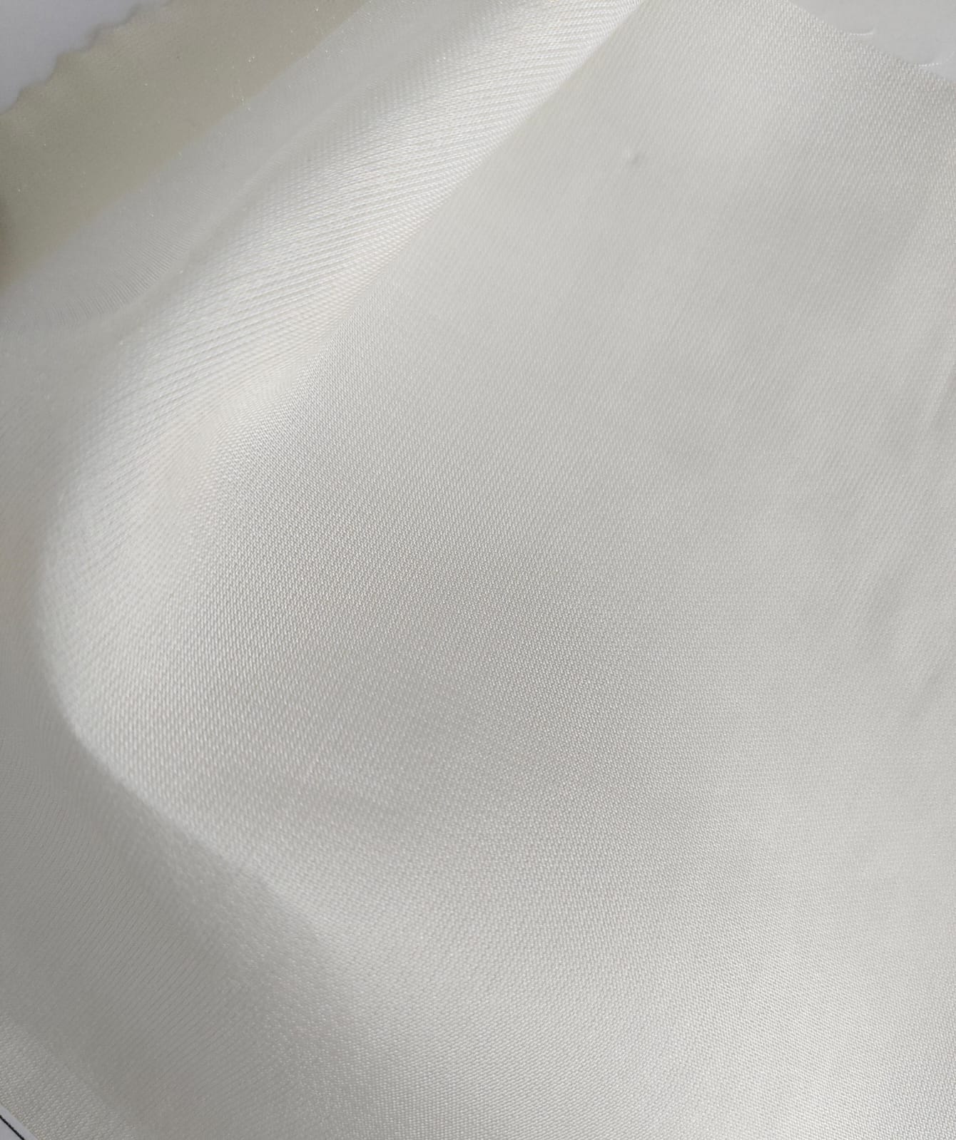 Close-up of soft, wrinkled pink cotton fabric displaying fine weave texture.