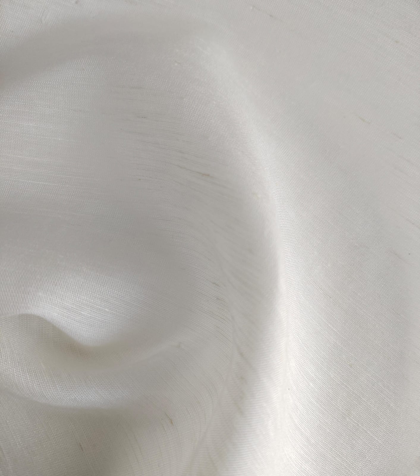Close-up of soft, wrinkled pink cotton fabric displaying fine weave texture.