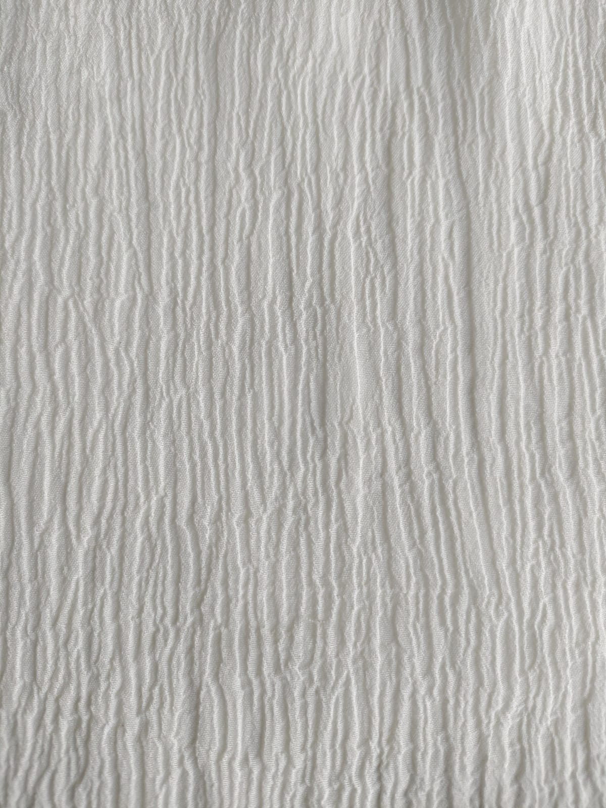 Close-up of soft, wrinkled pink cotton fabric displaying fine weave texture.