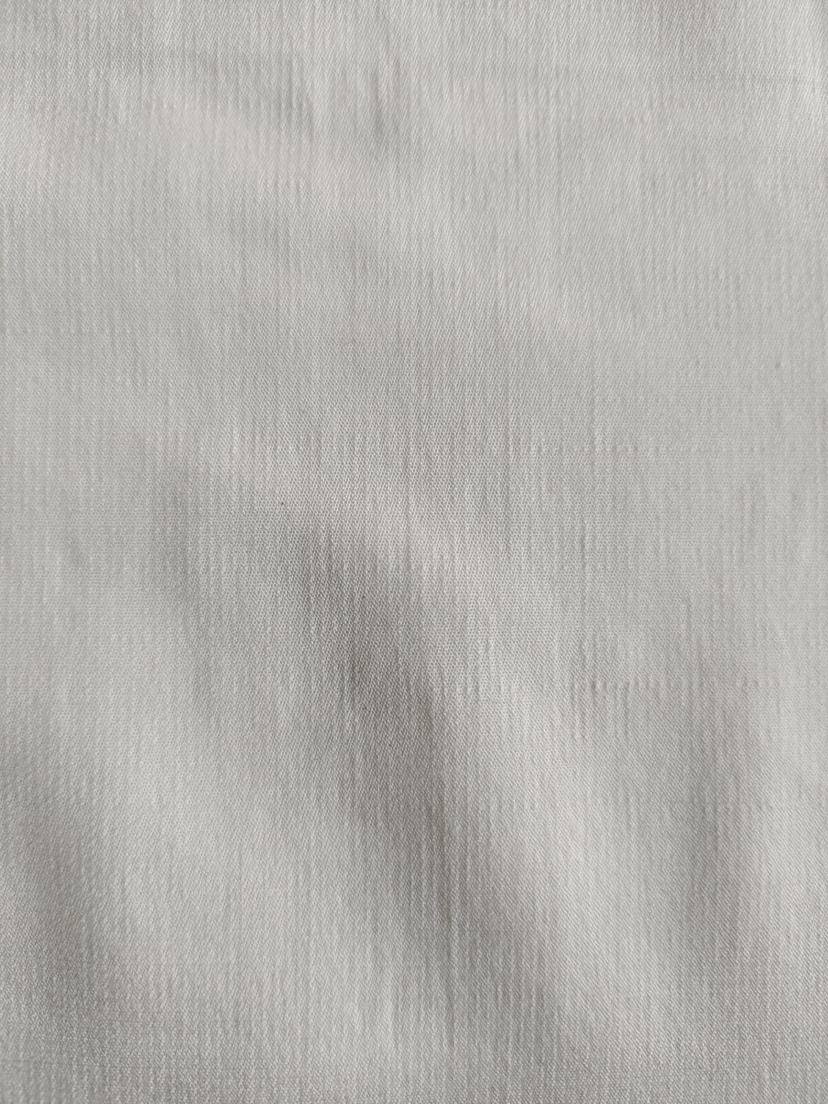 Close-up of soft, wrinkled pink cotton fabric displaying fine weave texture.
