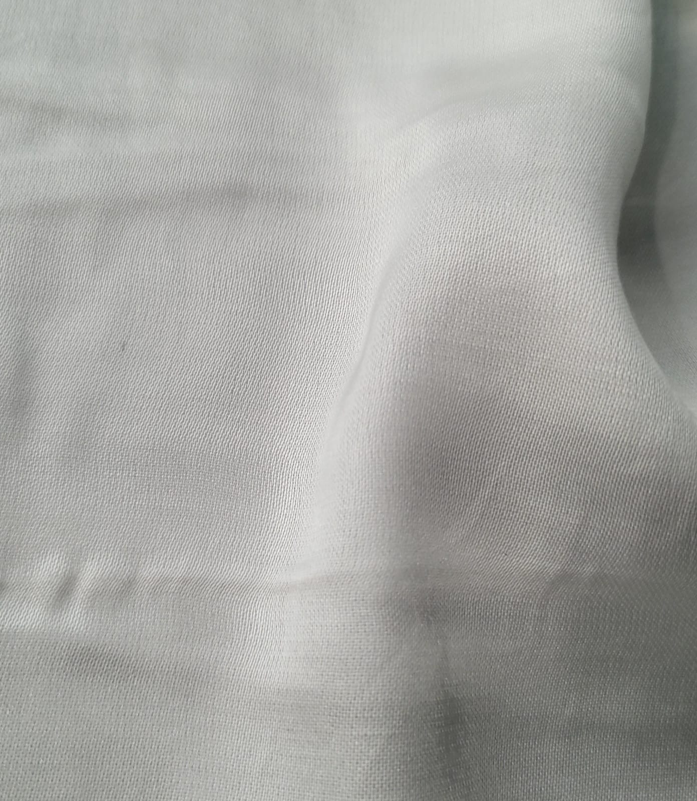 Close-up of soft, wrinkled pink cotton fabric displaying fine weave texture.