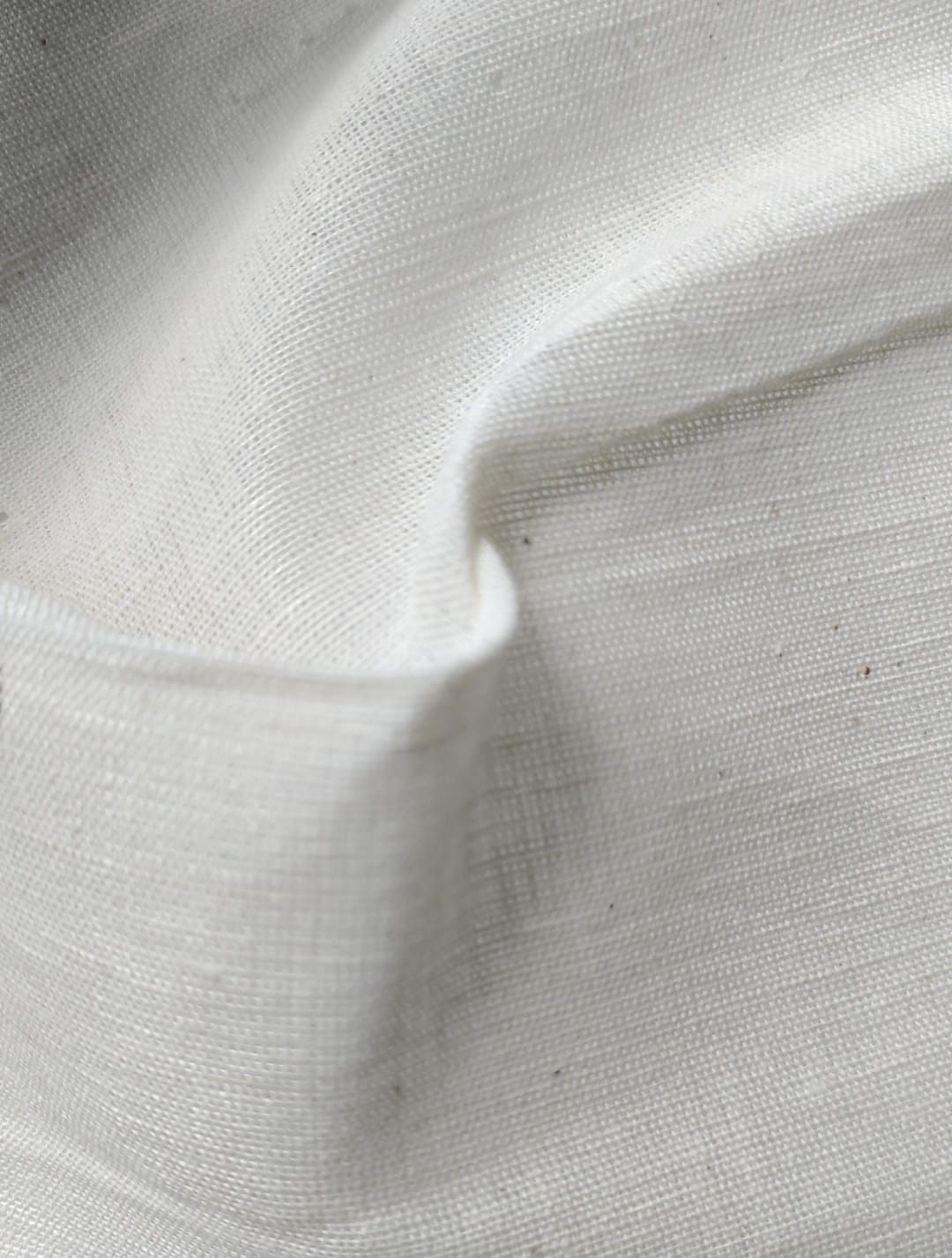 Close-up of soft, wrinkled pink cotton fabric displaying fine weave texture.