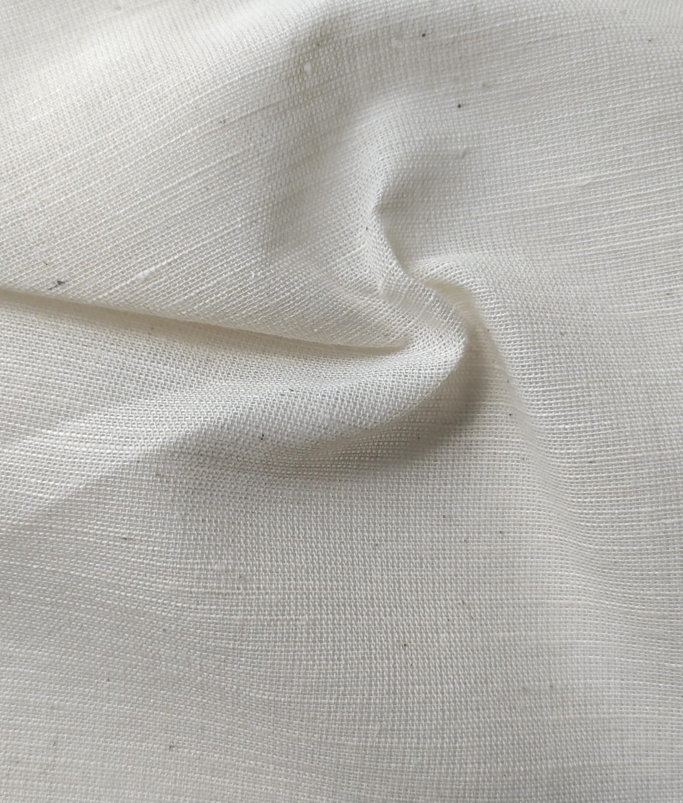 Close-up of soft, wrinkled pink cotton fabric displaying fine weave texture.