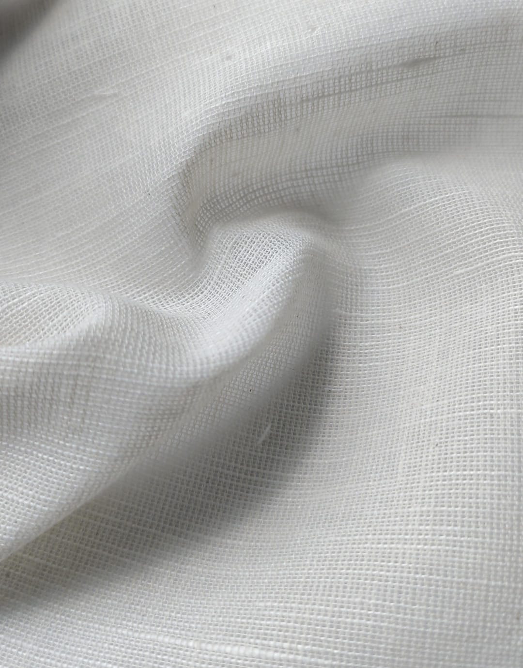 Close-up of soft, wrinkled pink cotton fabric displaying fine weave texture.