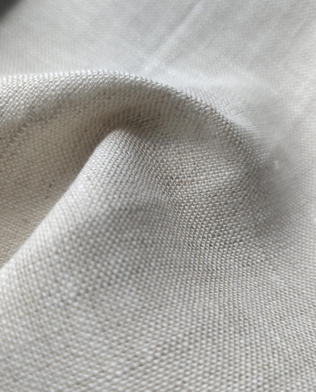 Close-up of soft, wrinkled pink cotton fabric displaying fine weave texture.