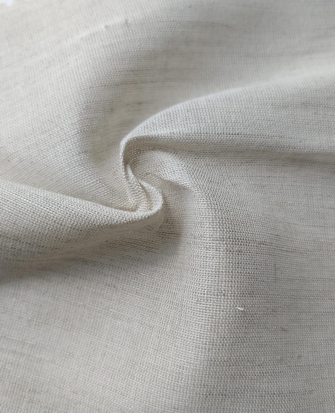 Close-up of soft, wrinkled pink cotton fabric displaying fine weave texture.