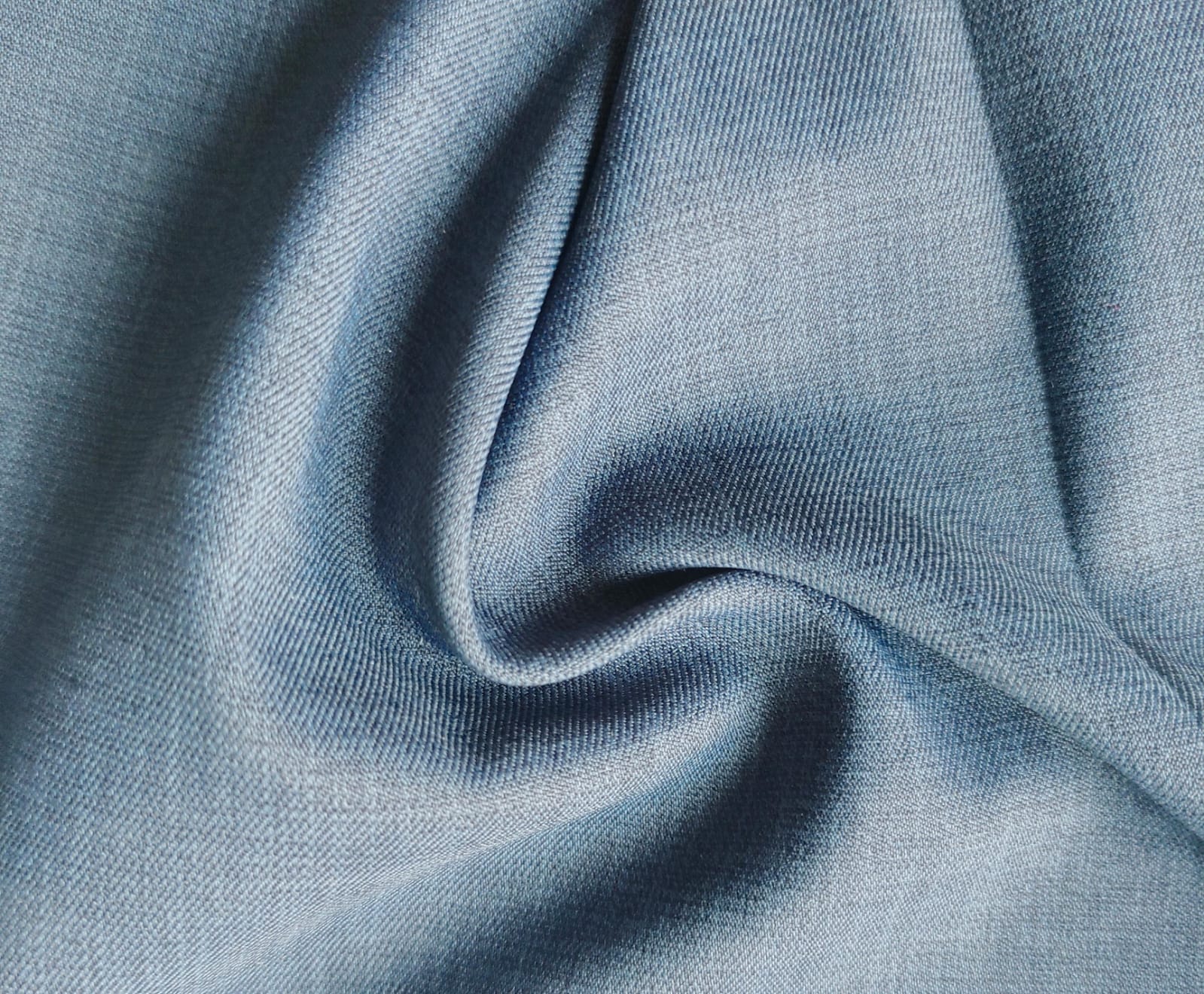 Close-up of soft, wrinkled pink cotton fabric displaying fine weave texture.