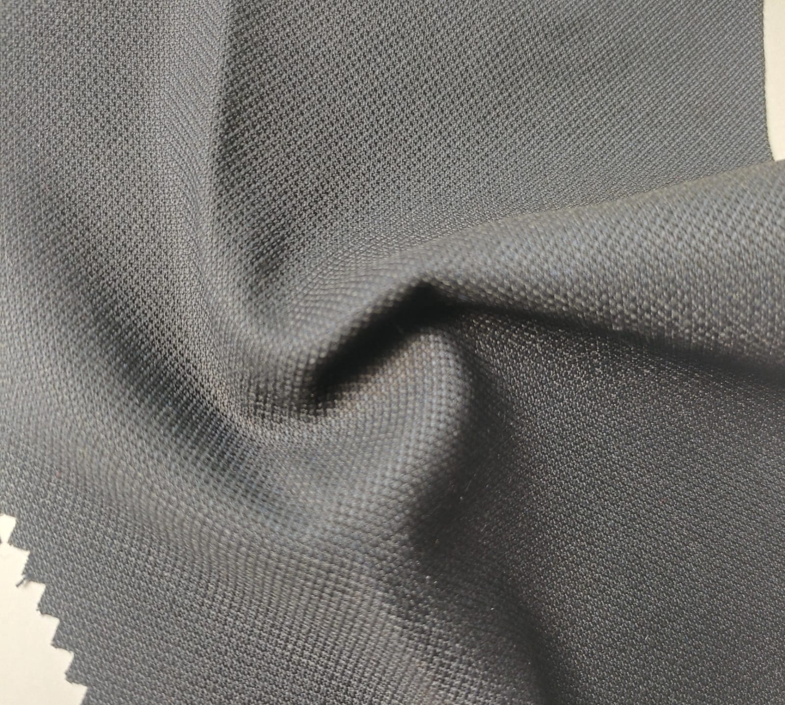 Close-up of soft, wrinkled pink cotton fabric displaying fine weave texture.