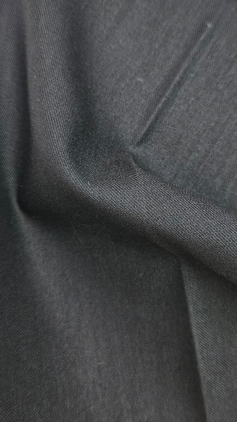 Close-up of soft, wrinkled pink cotton fabric displaying fine weave texture.