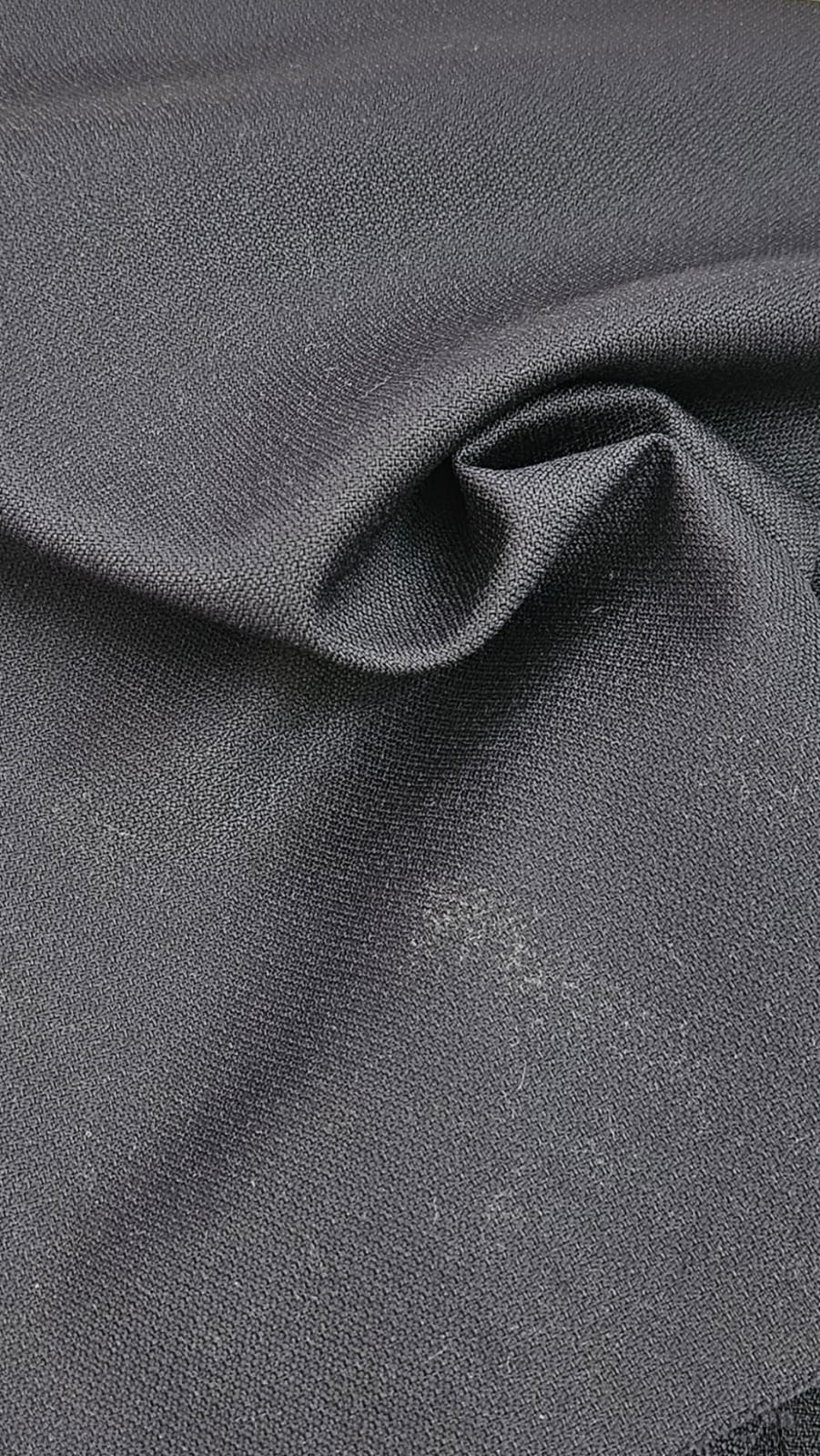 Close-up of soft, wrinkled pink cotton fabric displaying fine weave texture.