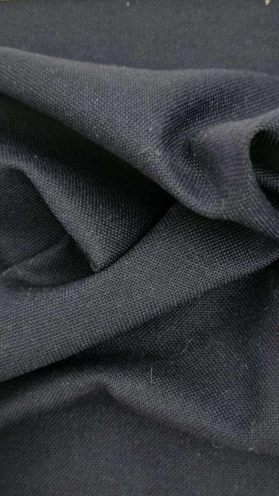 Close-up of soft, wrinkled pink cotton fabric displaying fine weave texture.