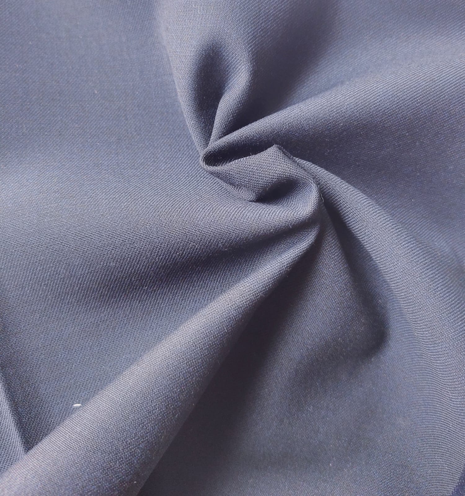 Close-up of soft, wrinkled pink cotton fabric displaying fine weave texture.