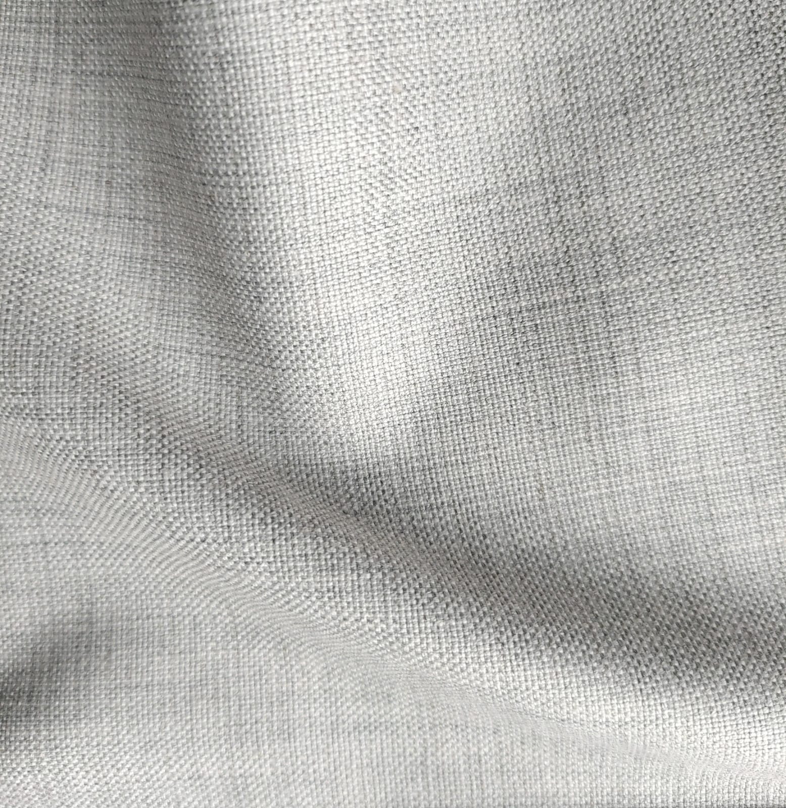 Close-up of soft, wrinkled pink cotton fabric displaying fine weave texture.