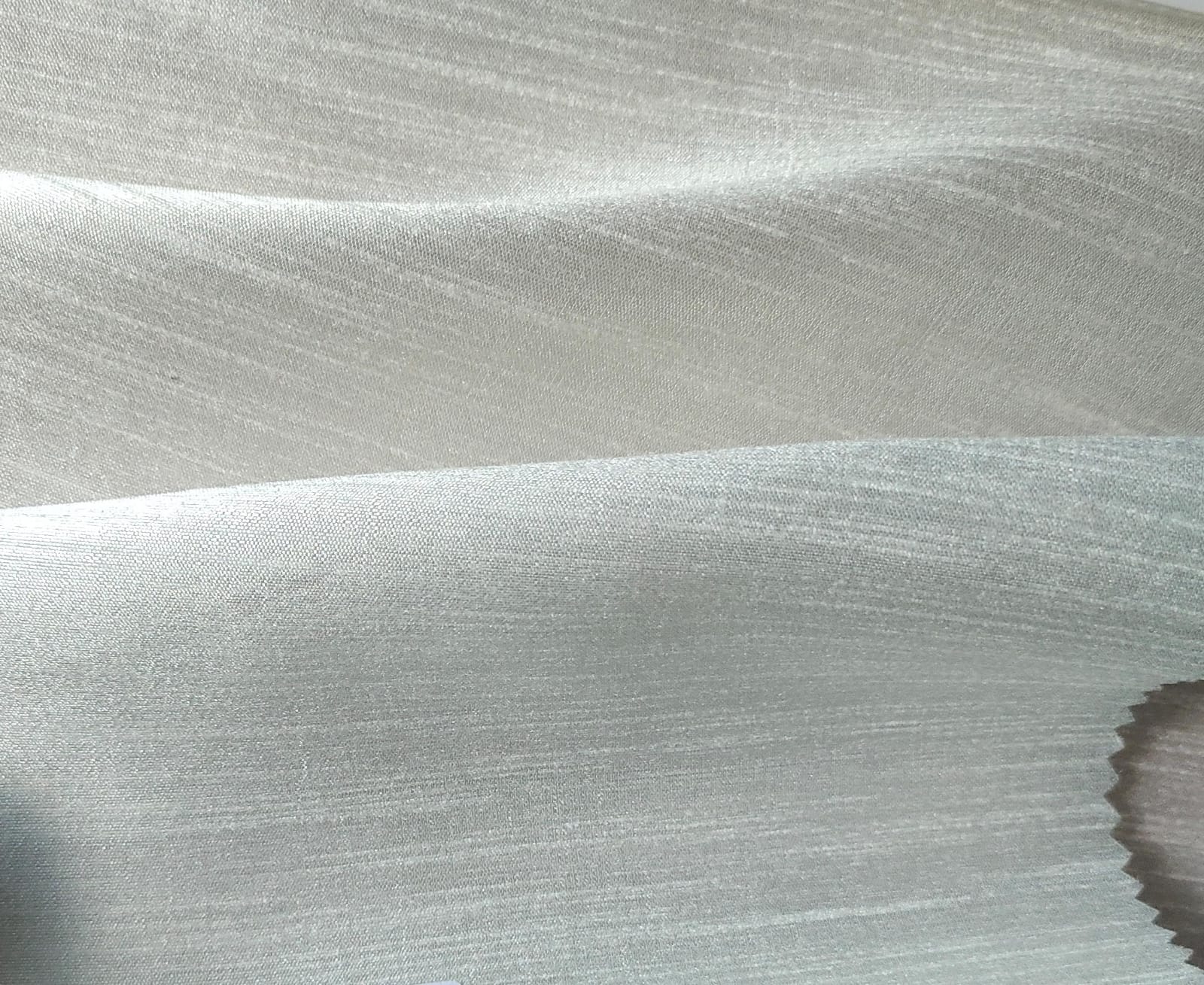 Close-up of soft, wrinkled pink cotton fabric displaying fine weave texture.