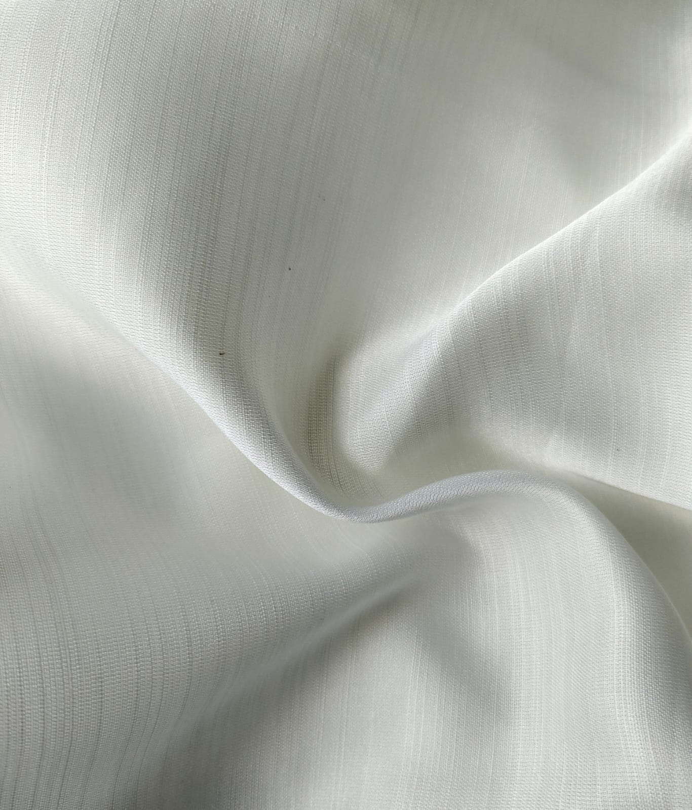 Close-up of soft, wrinkled pink cotton fabric displaying fine weave texture.
